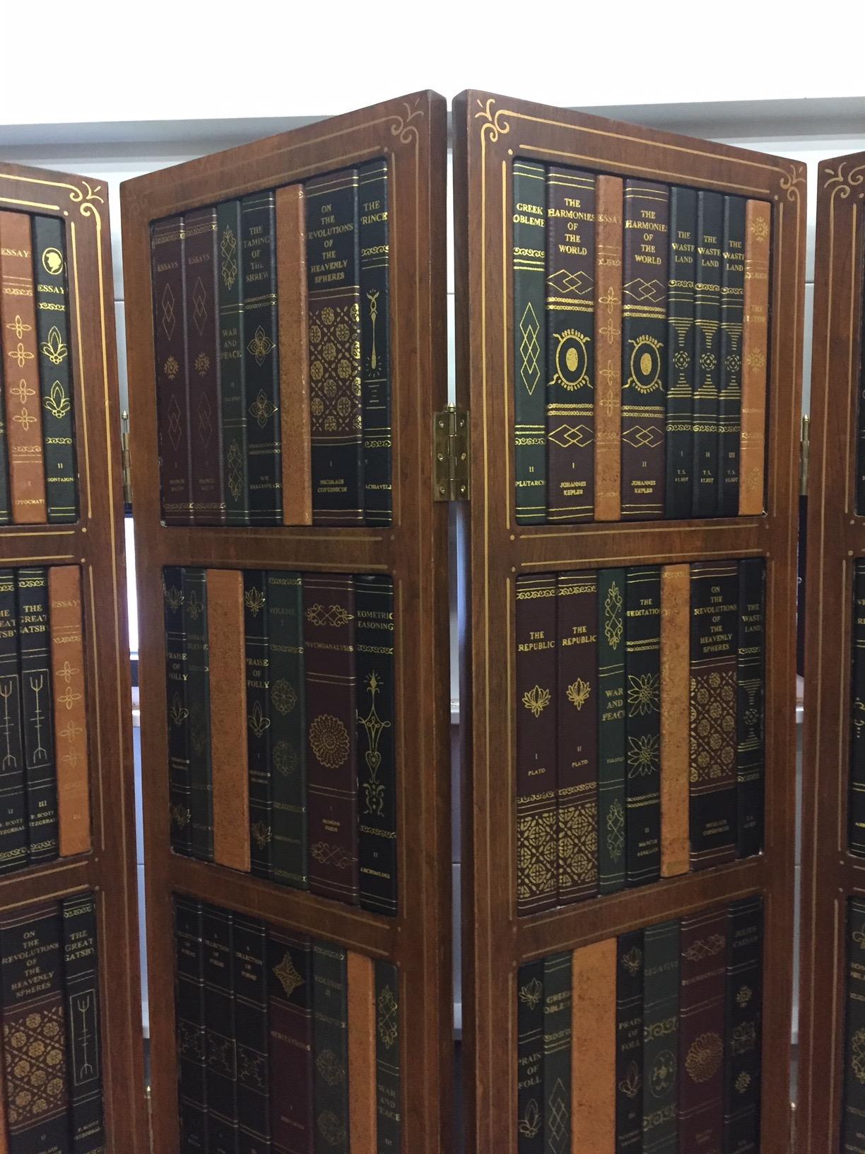 Richly textured tromp l'oeil screen that looks like lined library shelves with a marvelous collection of leather books. Lower area appears as if inlaid wood with central sunburst medallions. Each panel is 15