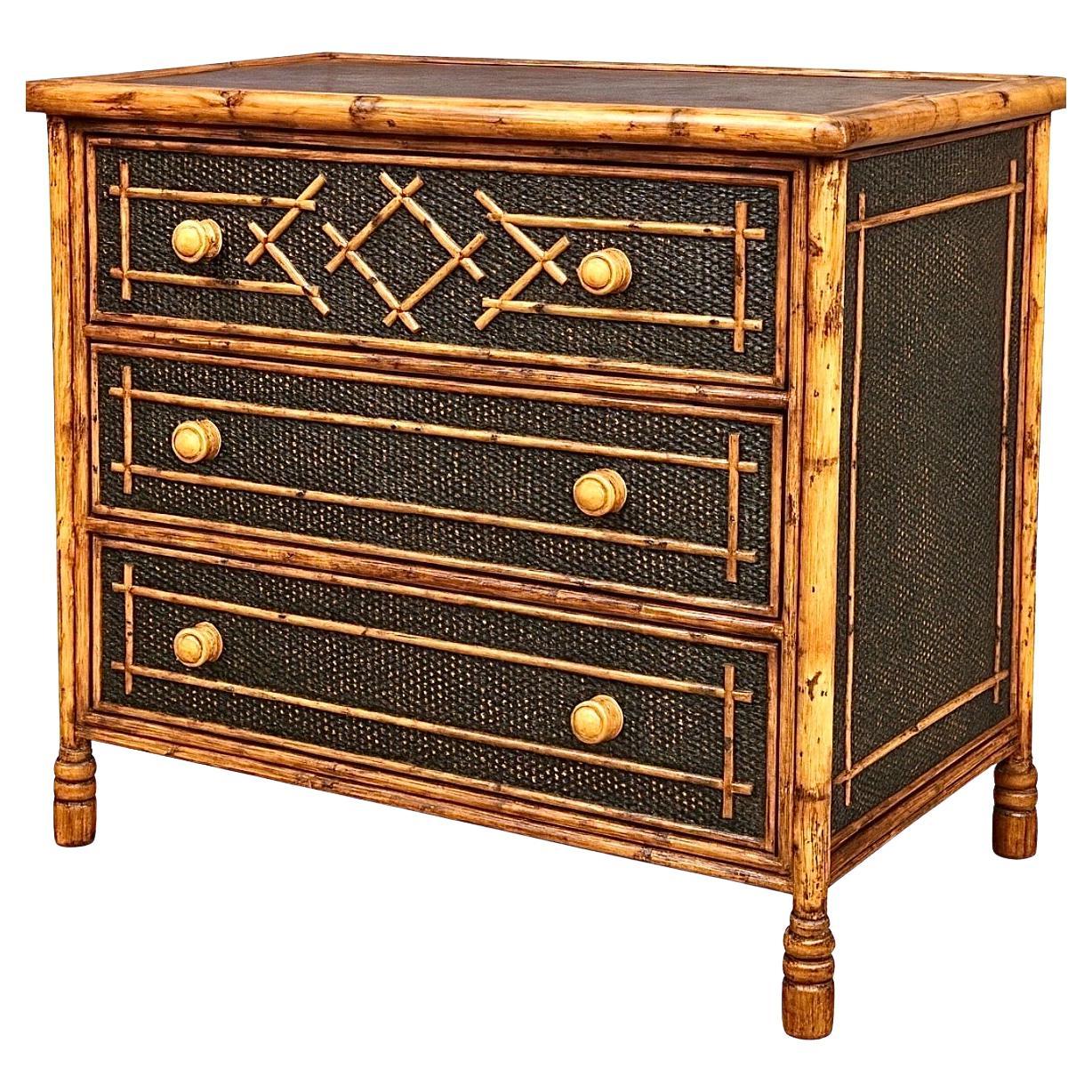 Un'imponente cassapanca vintage in stile British Colonial, del 1980 circa. Robusta struttura in legno duro impiallacciato in canna con dettagli in rattan e bambù. La finitura in ebano è splendidamente ossidata per rivelare sottili accenti di canna