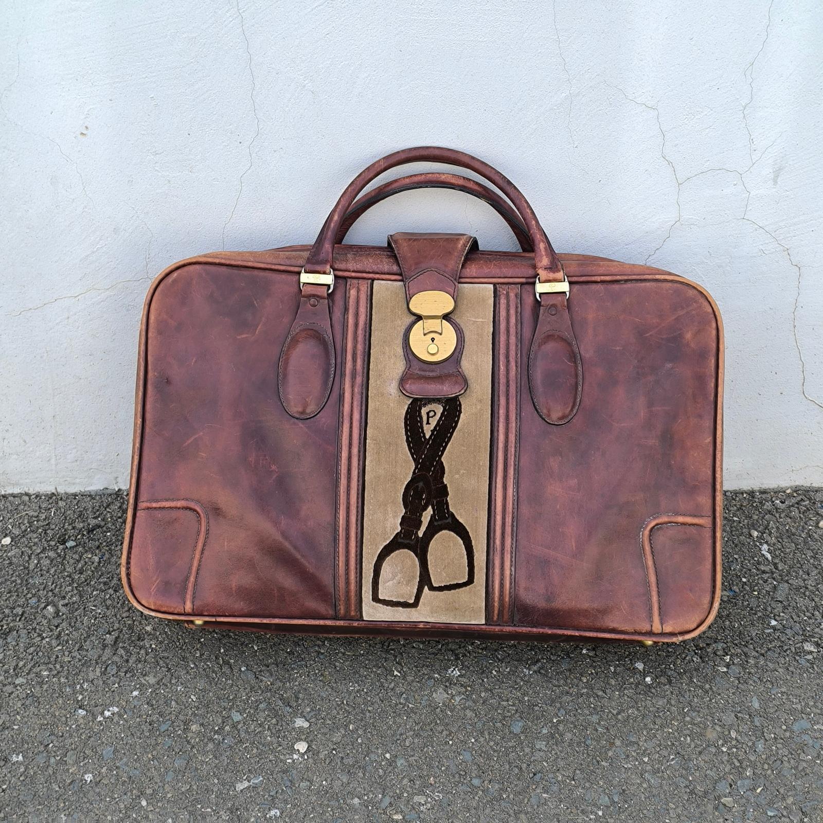 Bolsa de viaje vintage de piel suave de la marca de lujo Valigeria PRINCIPE. La línea vertical del centro es de terciopelo de color topo con el dibujo del logotipo de la marca, sujeta por dos asas de piel-cierre con cremallera integral en dos partes