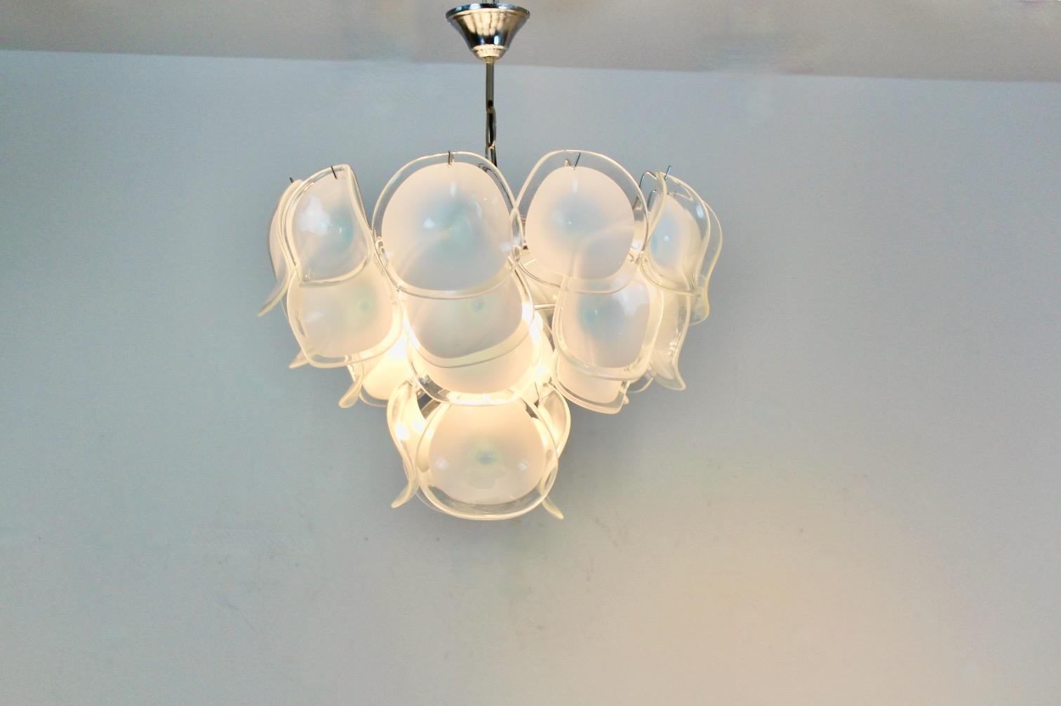 Wonderful Chandelier, attributed to Vistosi, with 28 handblown Murano glass curved discs made in Italy, 1970s. Truly beautiful dynamic light partition, created by the curved white glass discs, which are handmade. The discs are mounted on three
