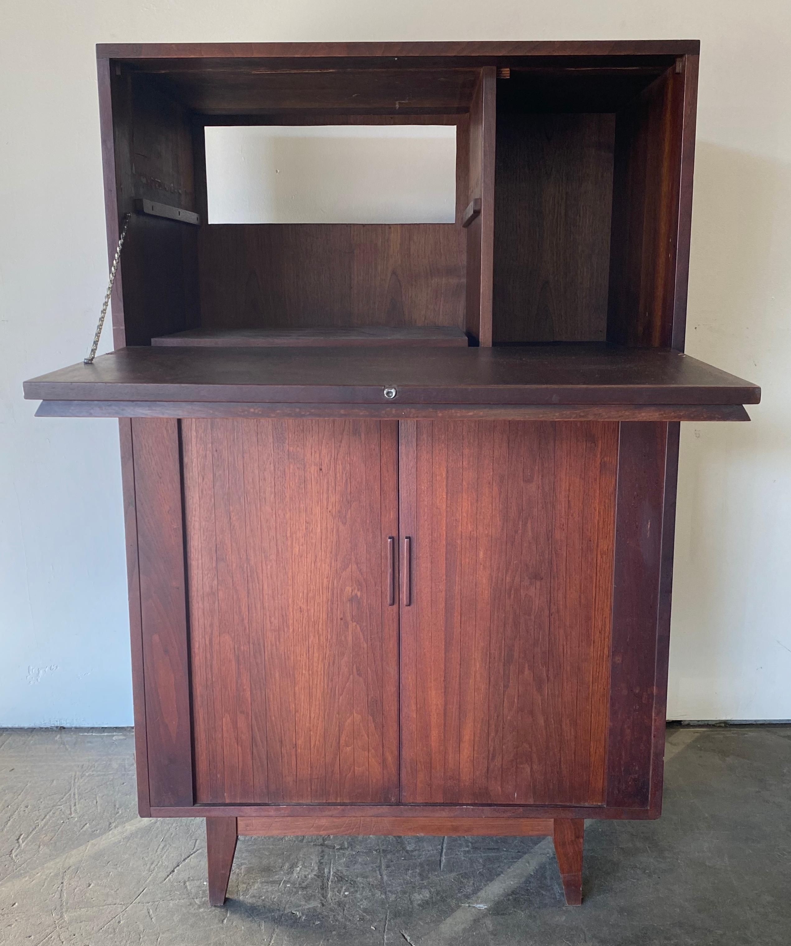 Custom built bar cabinet. Dates to the 1960s. Purchased from the original owner who used it in Greenwich Village and then Greenwich, CT. Crafted from American black walnut with spectacular grain texture and color. Features generously sized to
