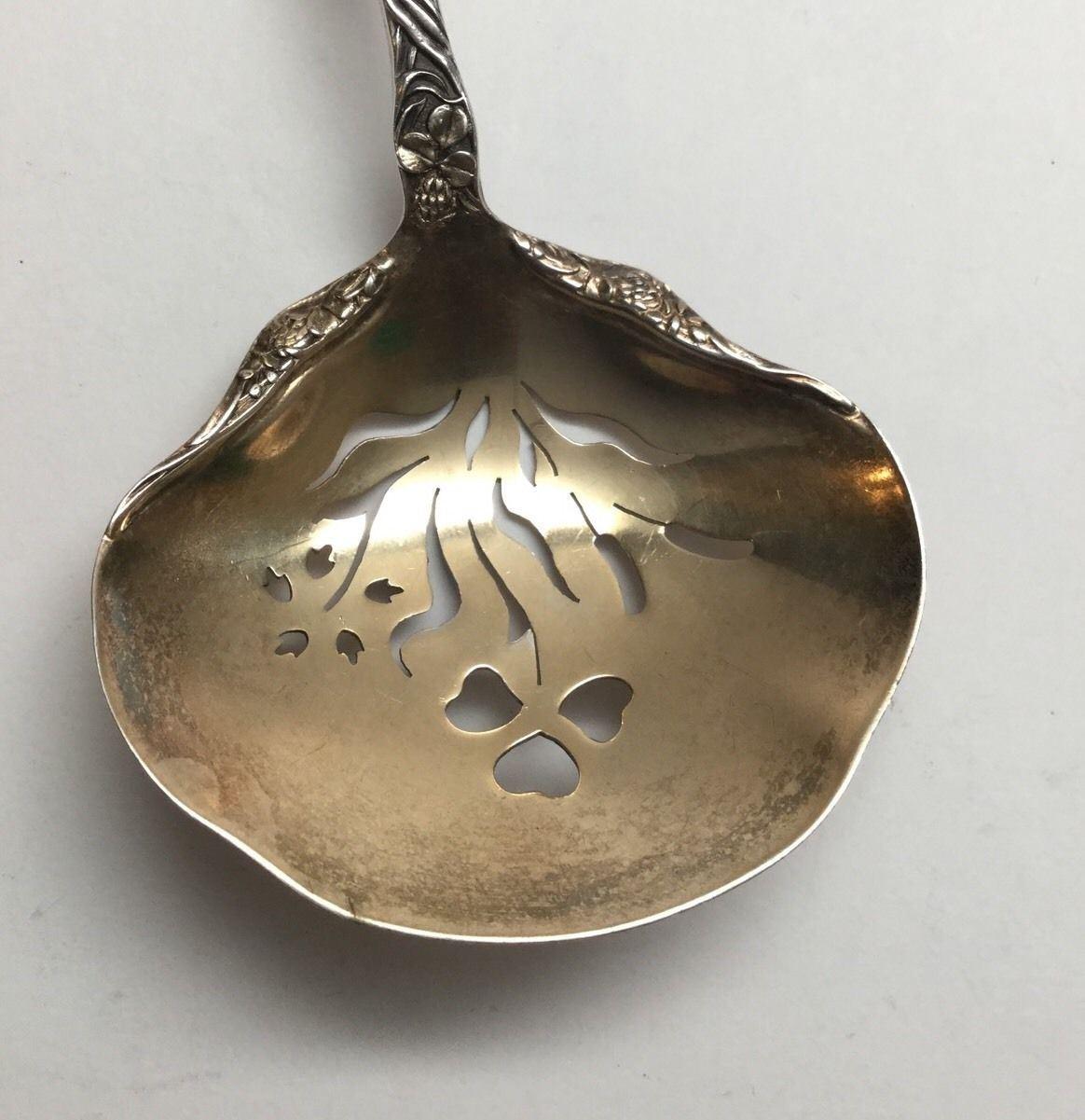 Antique Gorham sterling silver Bon Bon or nut serving spoon with gold washed pierced bowl in the 1897 Meadow pattern. Marked: lion anchor G, STERLING, PAT.1897. 
Monogram appears to be a lower case 