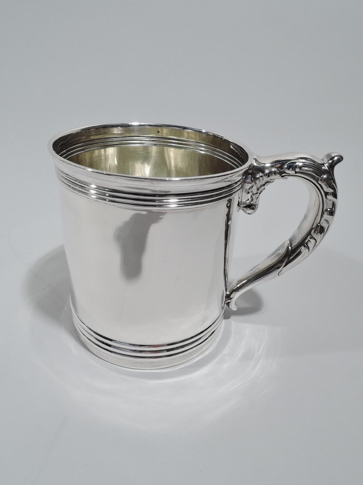 Classical sterling silver baby cup. Made by Gorham in providence in 1893. Gently upward tapering sides with ribbed bands at top and bottom. Leaf-capped and shell-mounted scroll handle. Fully marked including maker’s stamp, date symbol, and no. 4718.