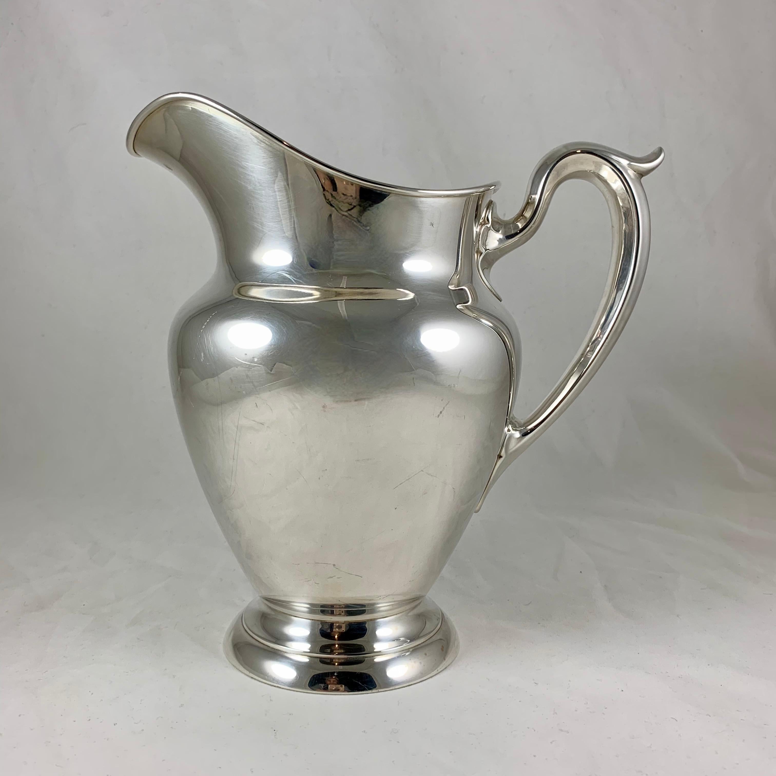 From Gorham, a large sterling silver water pitcher with a full bulbous shaped body and a scroll handle, on a rounded base. The wide pour spout has a rolled rim.

A simply beautiful form.
Marked with the Gorham hallmark, Sterling 182, and the date