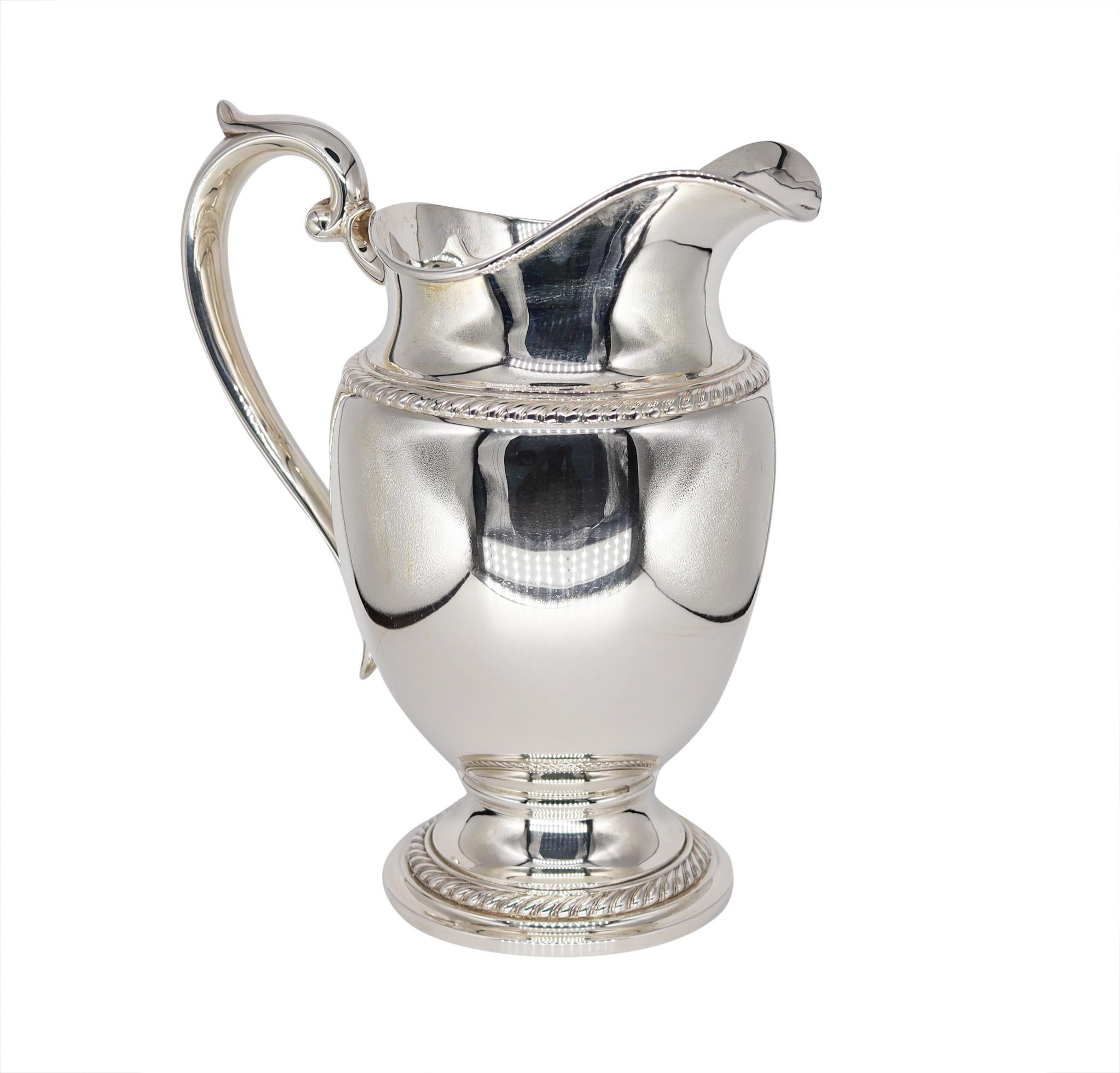 Classic water pitcher ewer designed by Gorham.

Beautiful vintage American piece from Gorham. A large water pitcher crafted in solid .925/.999 sterling silver, back in the 1948. Designed with a full bulbous shaped body and a scroll handle, on a
