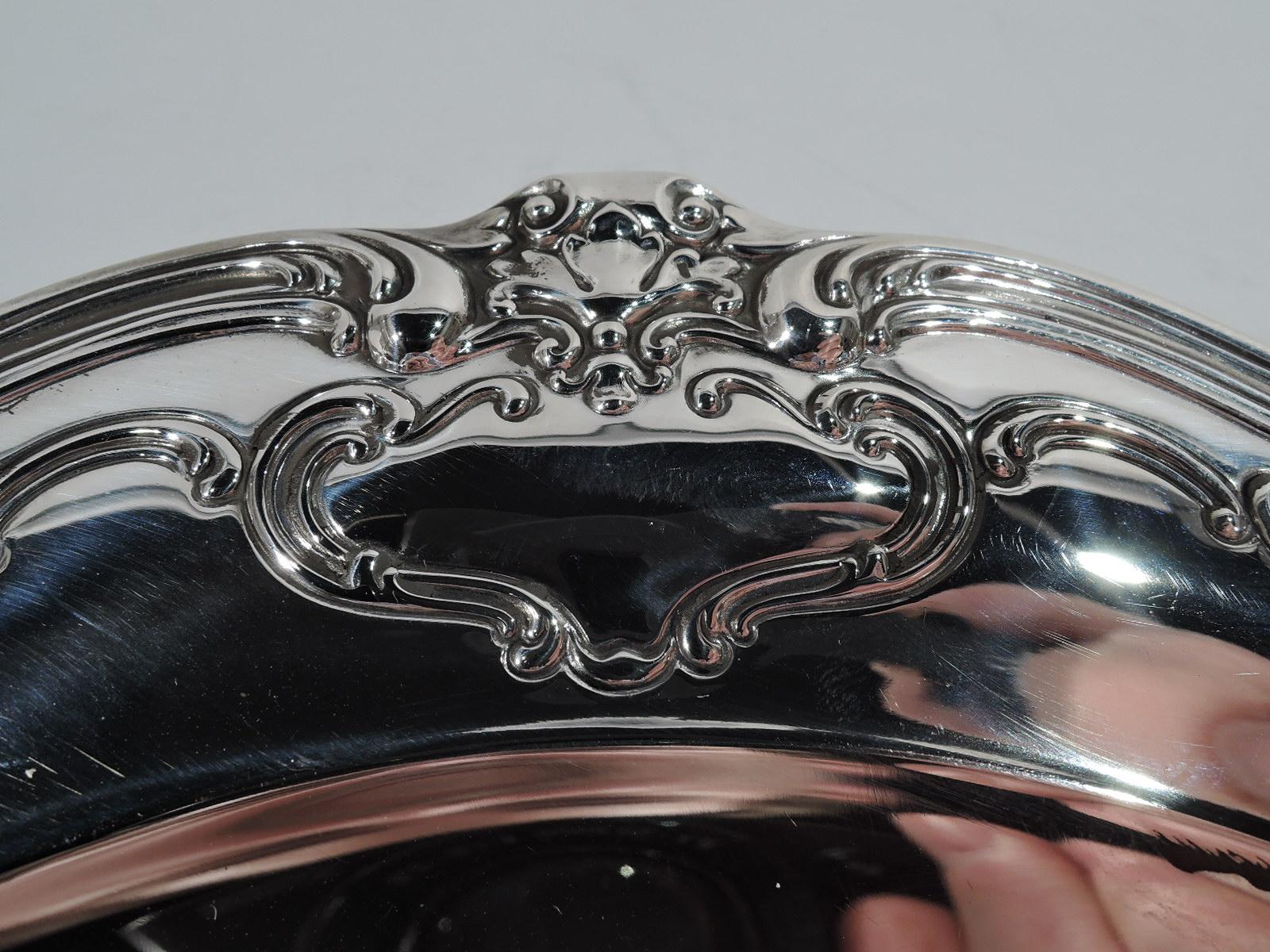 Pretty Art Nouveau sterling silver serving plate in Chantilly-Duchess pattern. Made by Gorham in Providence in 1954. Round well and scrolled rim with chased ornament with fluid scrolls and frames (vacant). Fully marked including no. 746 and date