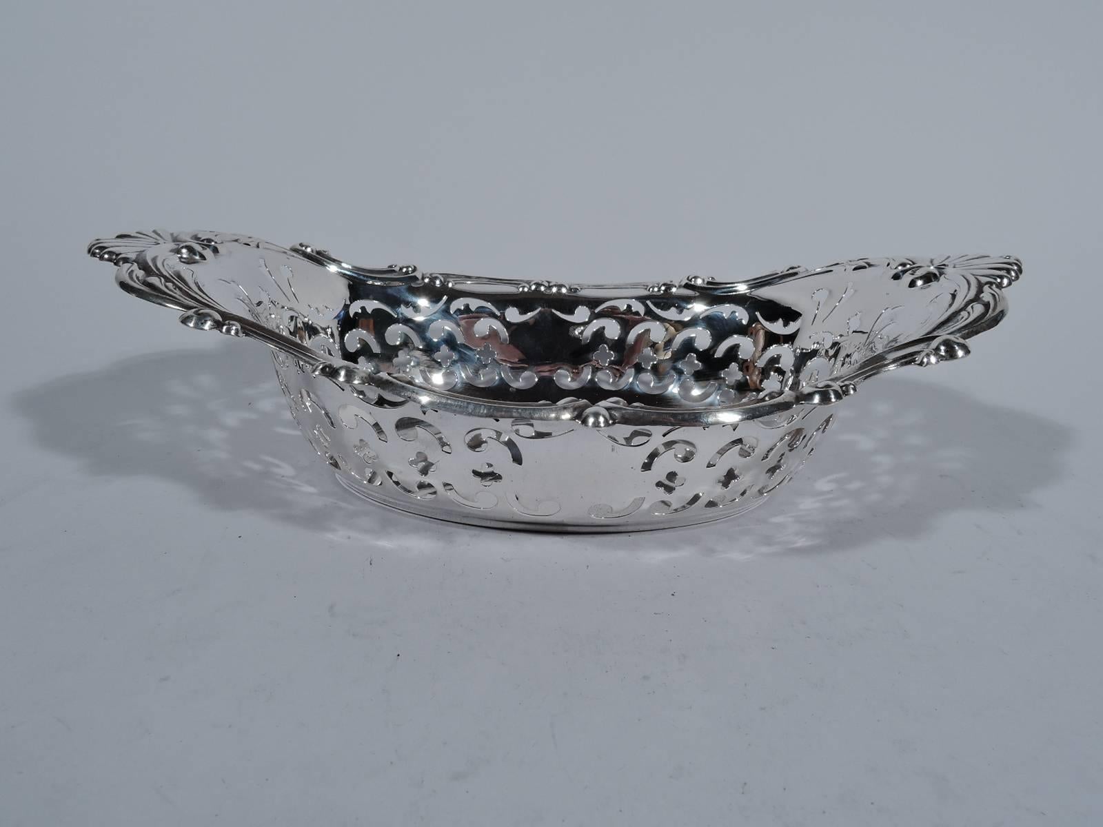 Classical sterling silver bowl. Made by Gorham in Providence in 1952. Well is solid and oval and sides have pierced scrolls and quatrefoils. Rim has C-scrolls and scallop shells at ends. A pretty piece in the traditional style. Hallmark includes