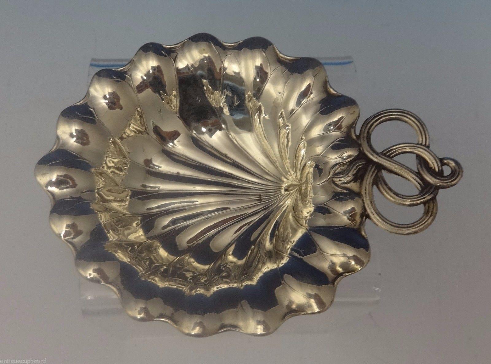 Gorham / Durgin
Gorham/Durgin sterling silver shell shape nut/mint dish and place card holder combination. It is marked with #5B. The measurements for the holder are 3/8 tall, 3 wide, and it weighs .9 ozt. It is not monogrammed and is in excellent