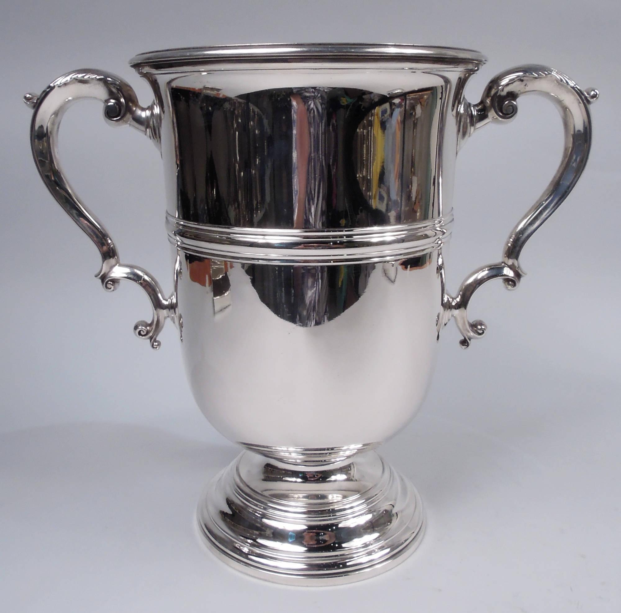 Classical sterling silver trophy cup. Made by Gorham in Providence, ca 1910. Tall girdled urn on stepped and domed foot; leaf-capped double-scroll side handles. Traditional form with extra space for engraving. Fully marked including maker’s stamp