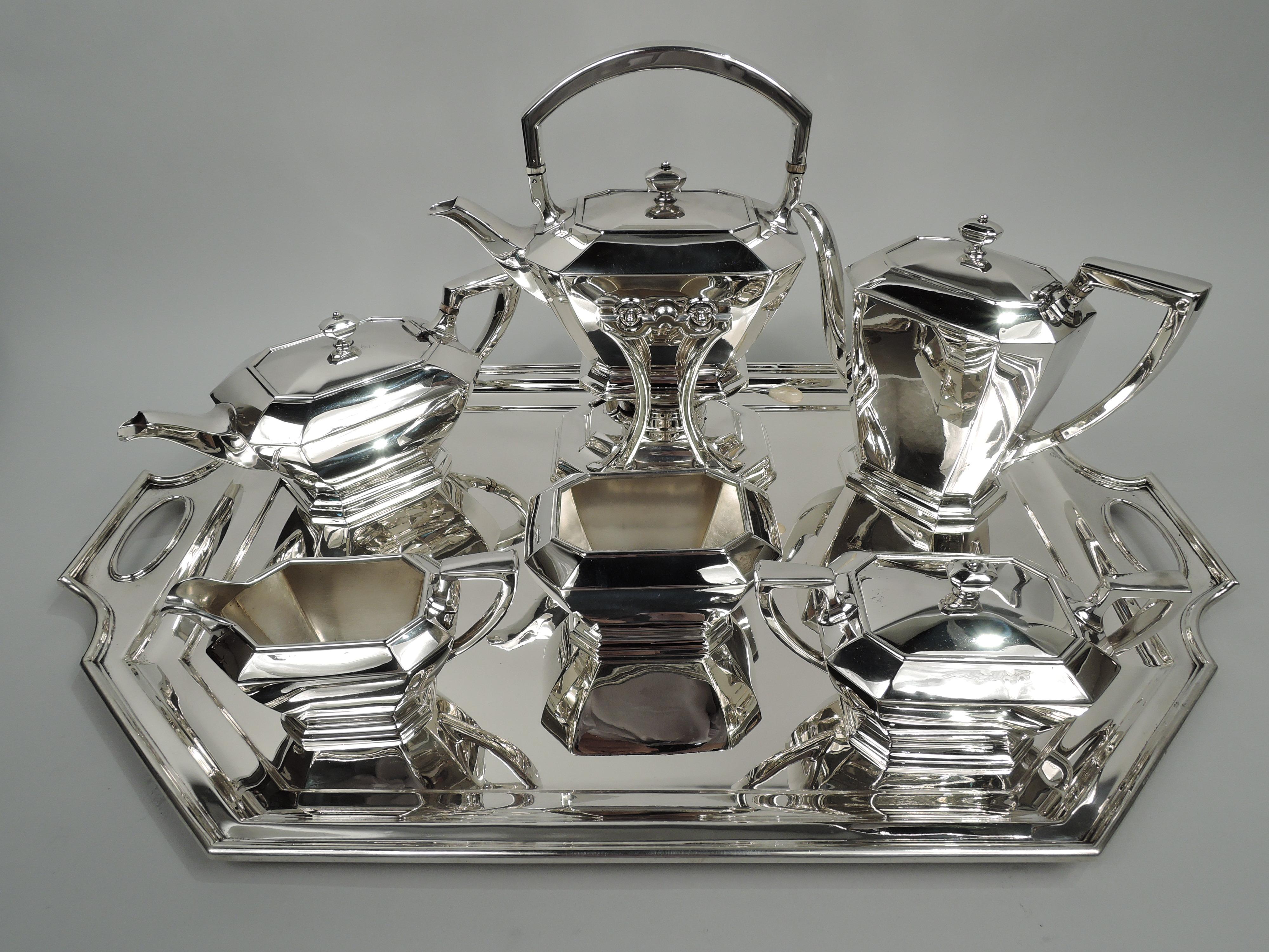 Fairfax sterling silver coffee and tea set on tray. Made by Durham, which was part of Gorham, in Concord, ca 1926. This set comprises 7 pieces: Hot water kettle on stand, coffeepot, teapot, creamer, sugar, and waste bowl on tray.

Each: Chamfered.
