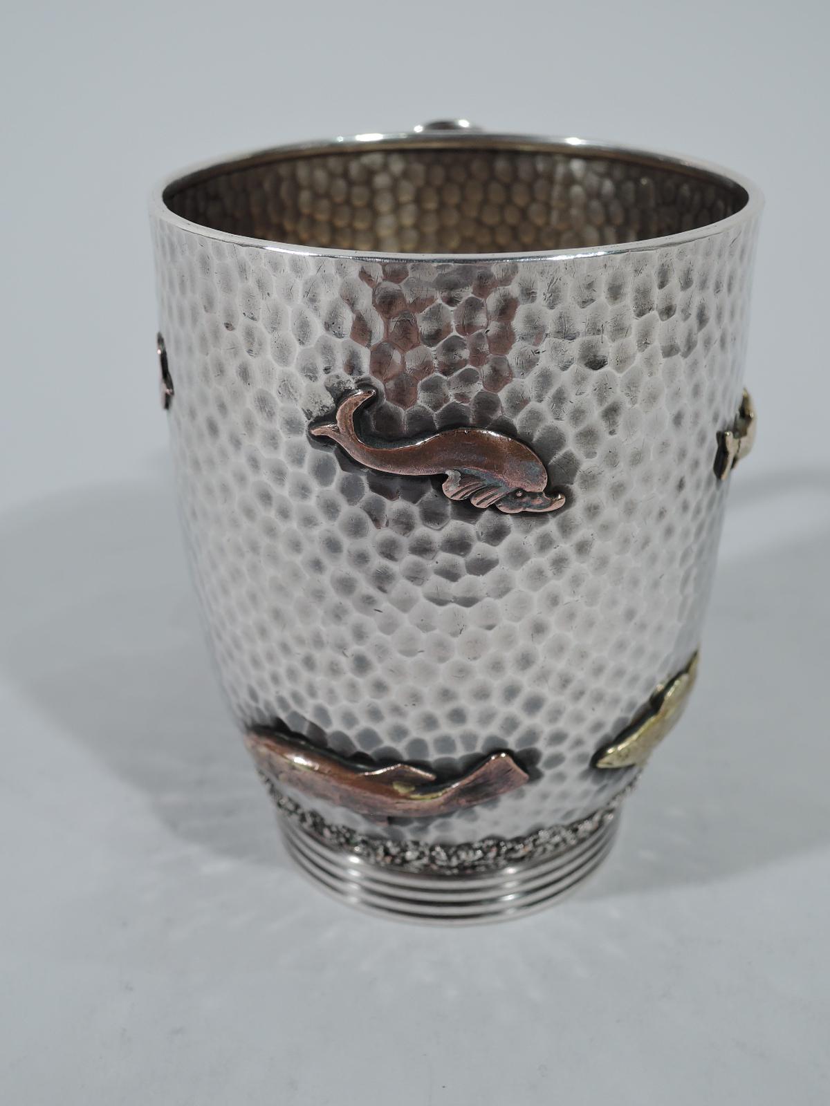 Japonesque hand-hammered sterling silver and mixed metal christening mug. Made by Gorham in Providence in 1879.
Gently curved sides with reeded and inset foot and plain oval-mounted C-scroll handle. Fish applied to all-over honeycomb ground: A