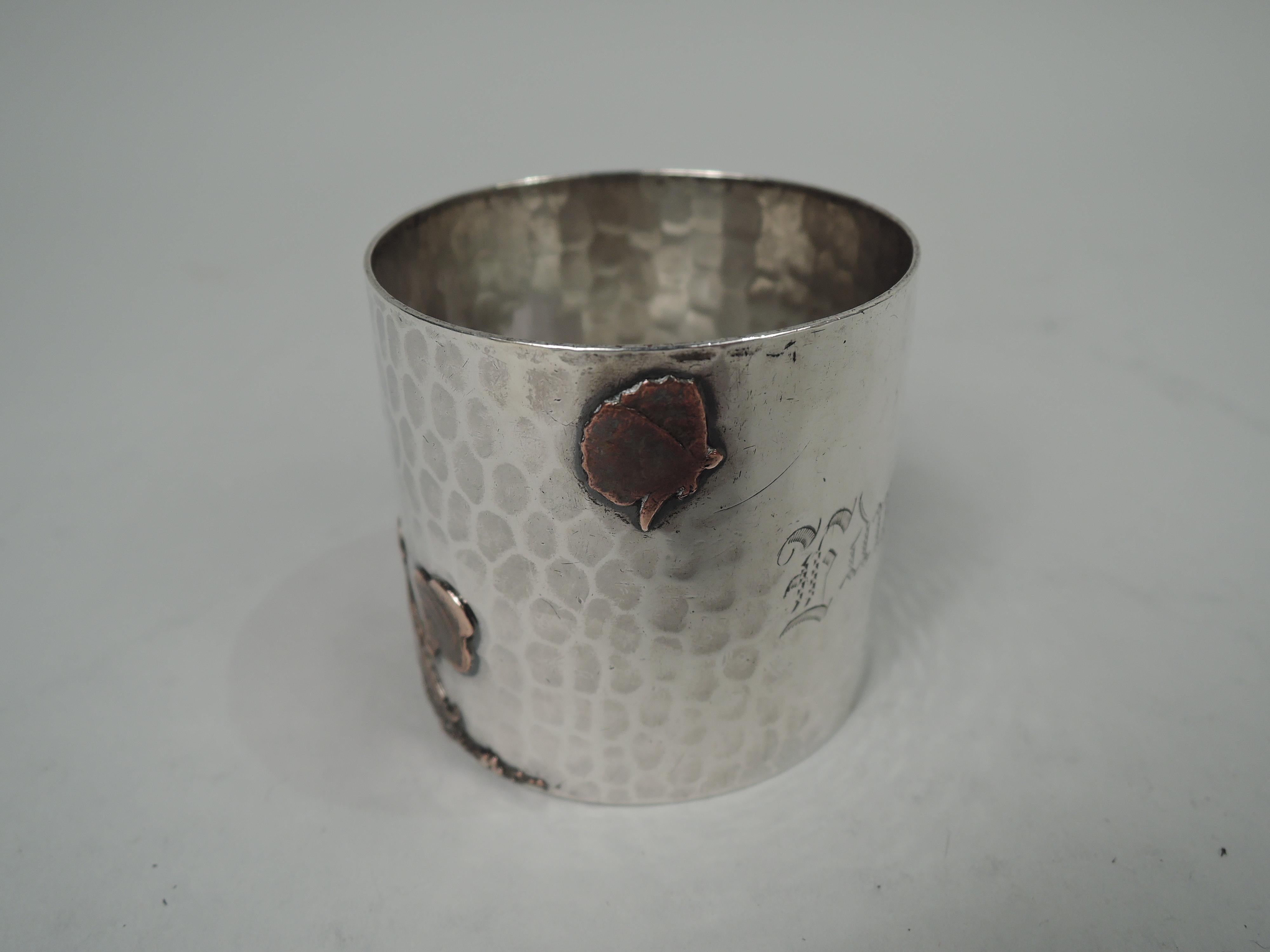 Japonesque mixed metal napkin ring. Made by Gorham in Providence in 1882. Hand-hammered sterling silver ring applied with cooper ornament: A man in pointy hat is seated on the ground, smoking while a small dog approaches from behind, interrupting