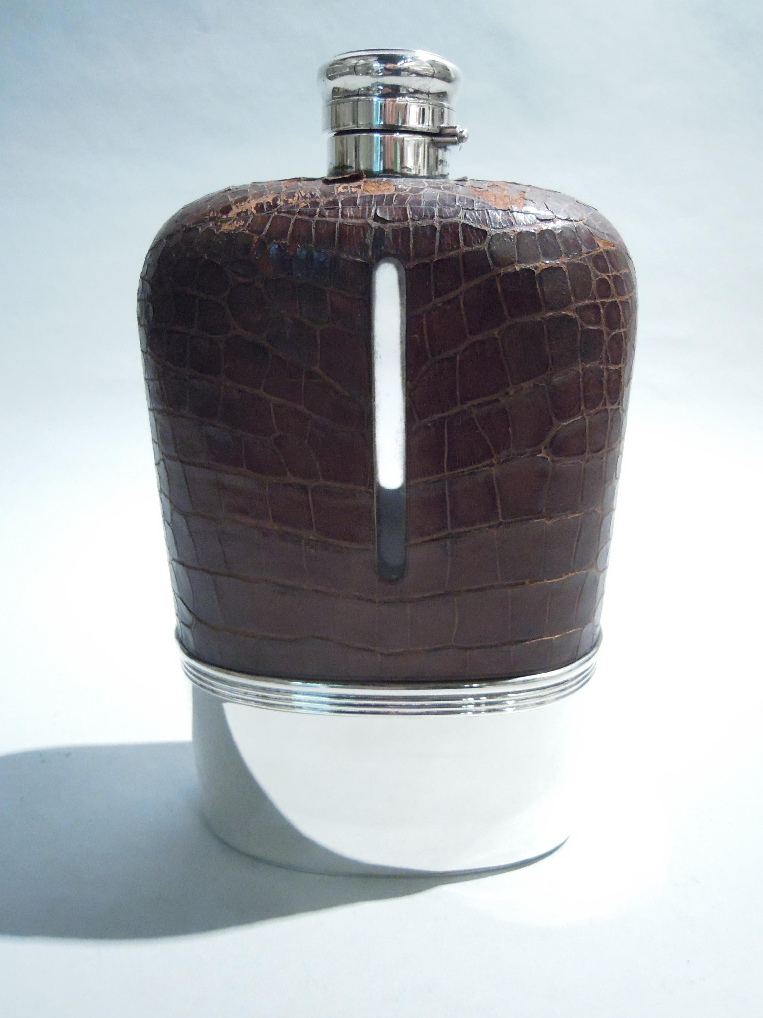 Victorian safari flask. Made by Gorham in Providence in 1896. Ovoid glass body. Top encased in leather with cutout tubular windows. Bottom has detachable sterling silver cup. Cover hinged and cork-lined. Holds 4 pints of chest-hair growing