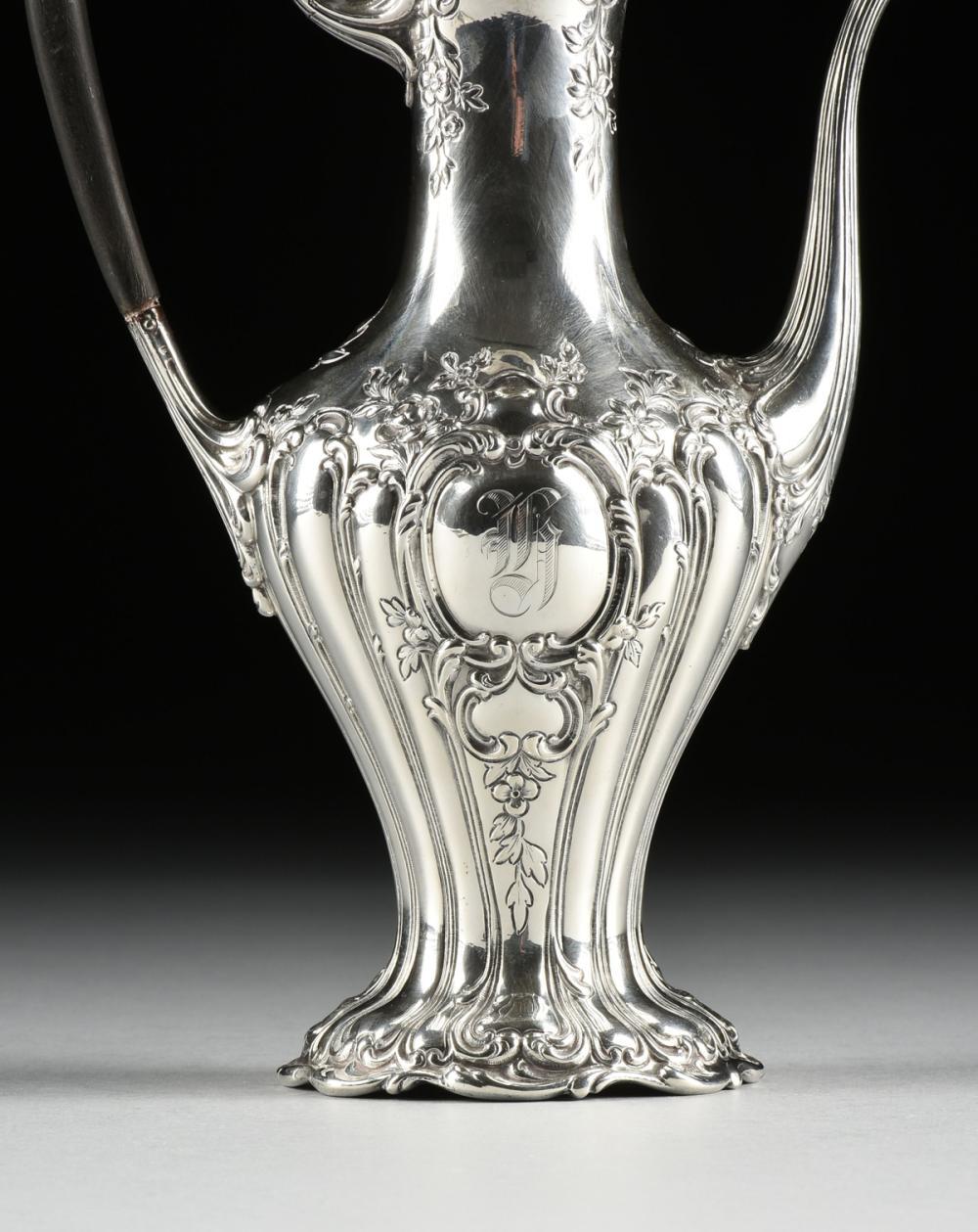 A Gorham Mfg. Co. sterling silver and ebony coffee pot, Providence, Rhode Island, 1903, of elongated baluster form with repoussé acanthus scroll, floral, and foliate decoration, and scroll bordered reserves at the front and back monogrammed 