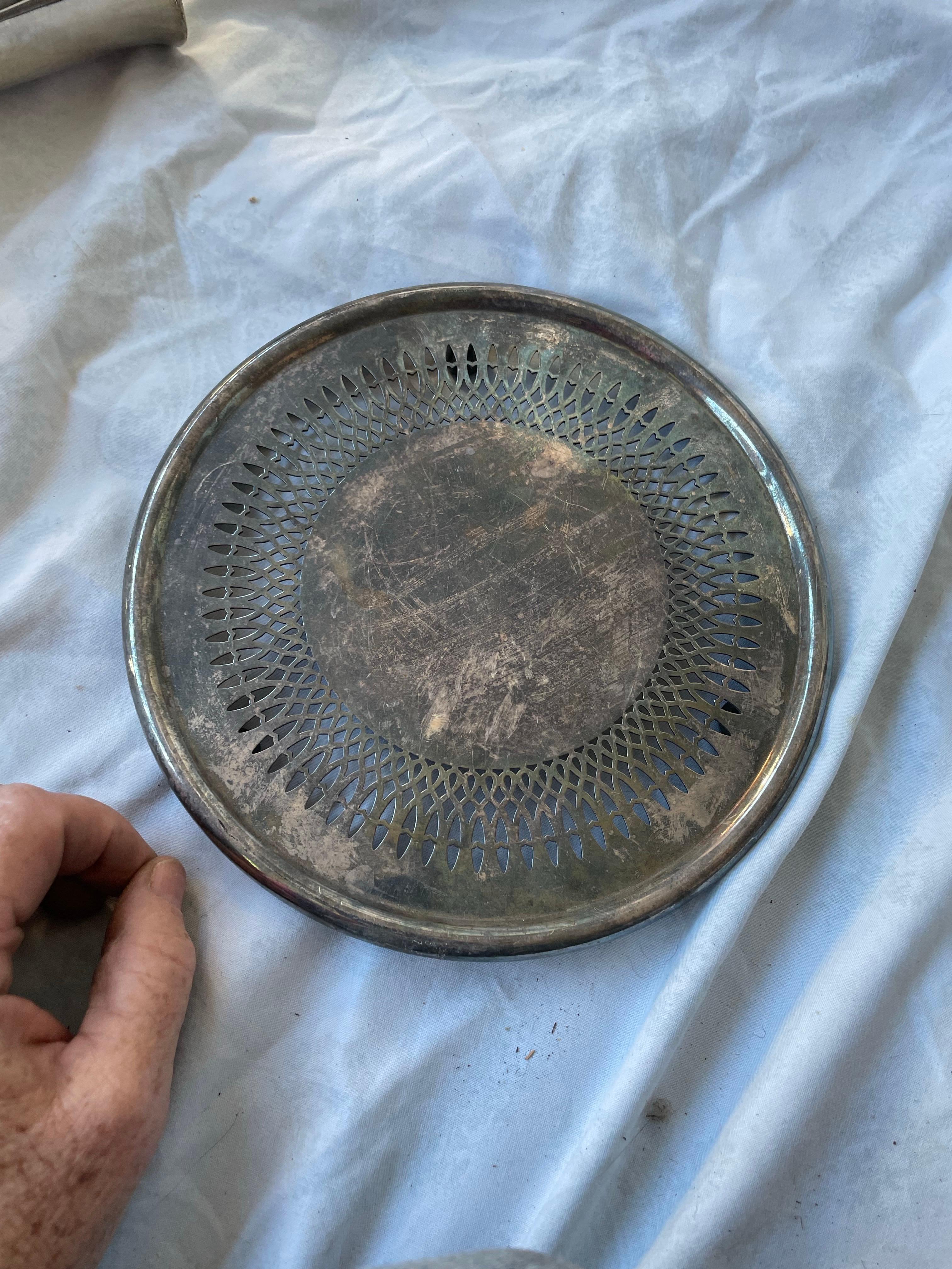 This is a nice, classic silver plate trivet made by The Gorham Silver Company from the Newport collection with a reticulated and rolled edge and nice feet.

It is 8 inches in diameter and about an inch high. There are scratches and signs of use, it