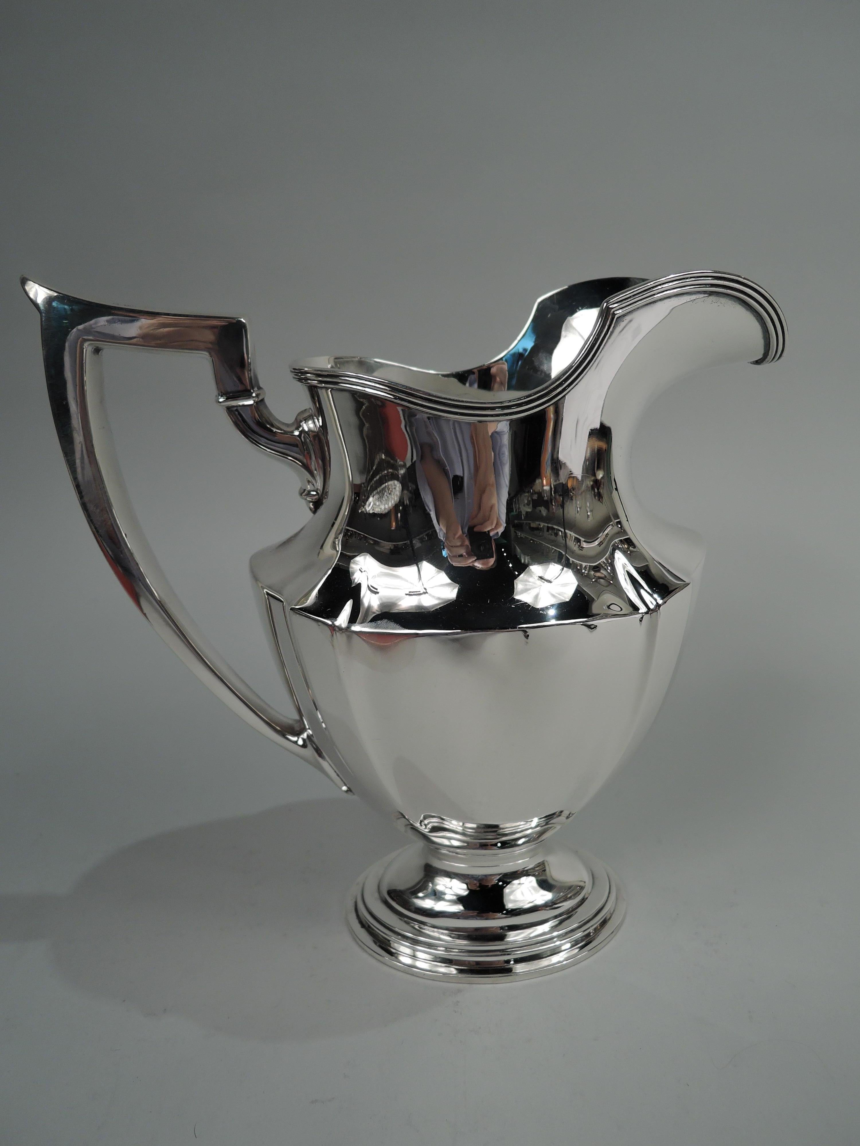 Plymouth sterling silver water pitcher. Made by Gorham in Providence in 1909. Tapering and paneled ovoid body, reeded helmet mouth, capped scroll bracket handle, and stepped oval foot. A fine piece in the classic pattern. Fully marked including