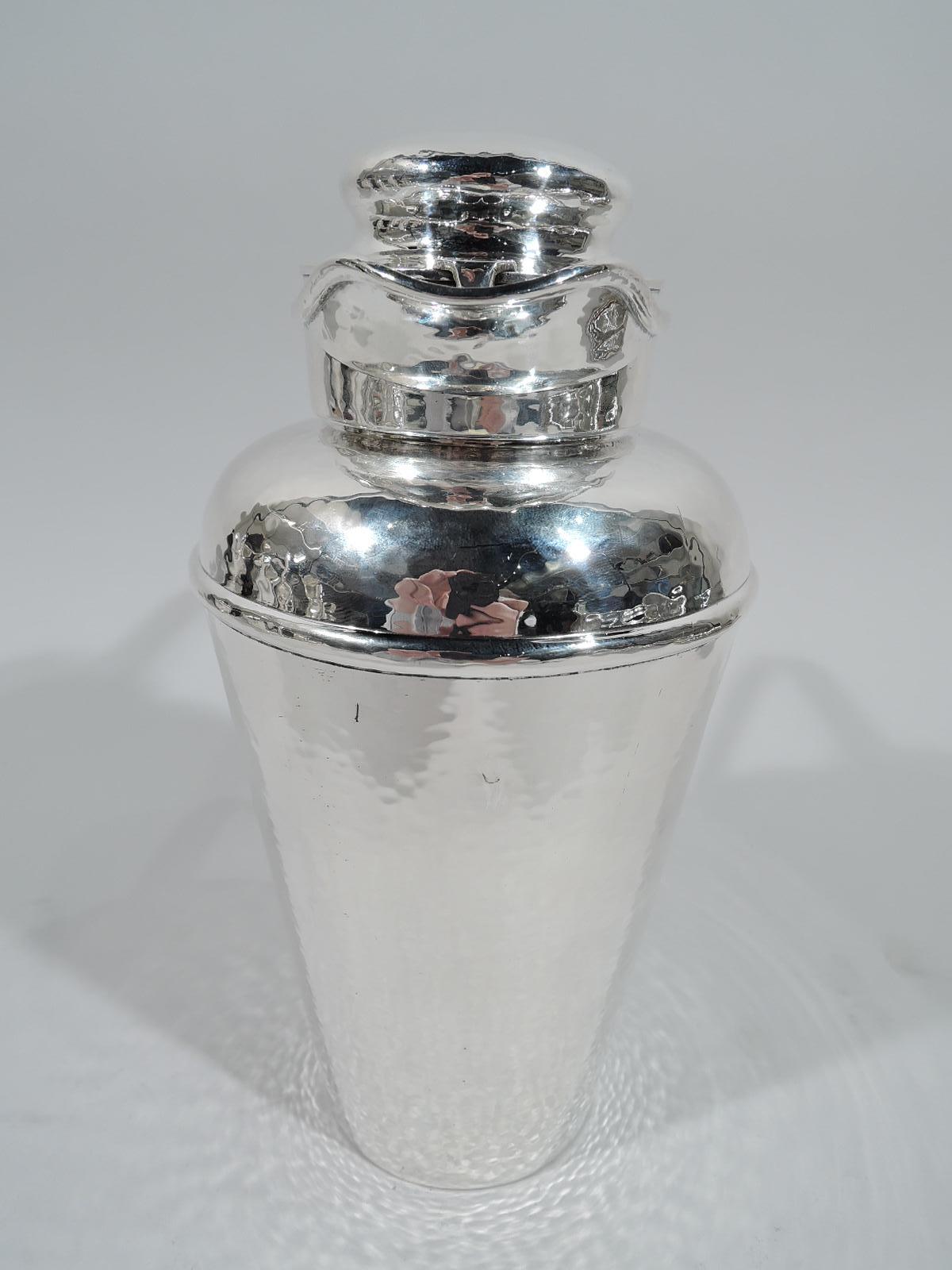 Prohibition-era sterling silver cocktail shaker. Made by Gorham in Providence in 1925. Conical bowl, curved shoulder, short neck, scroll bracket handle, and helmet-mouth with snug-fitting bun cover. Allover Craftsman-inspired hand-hammering. A great