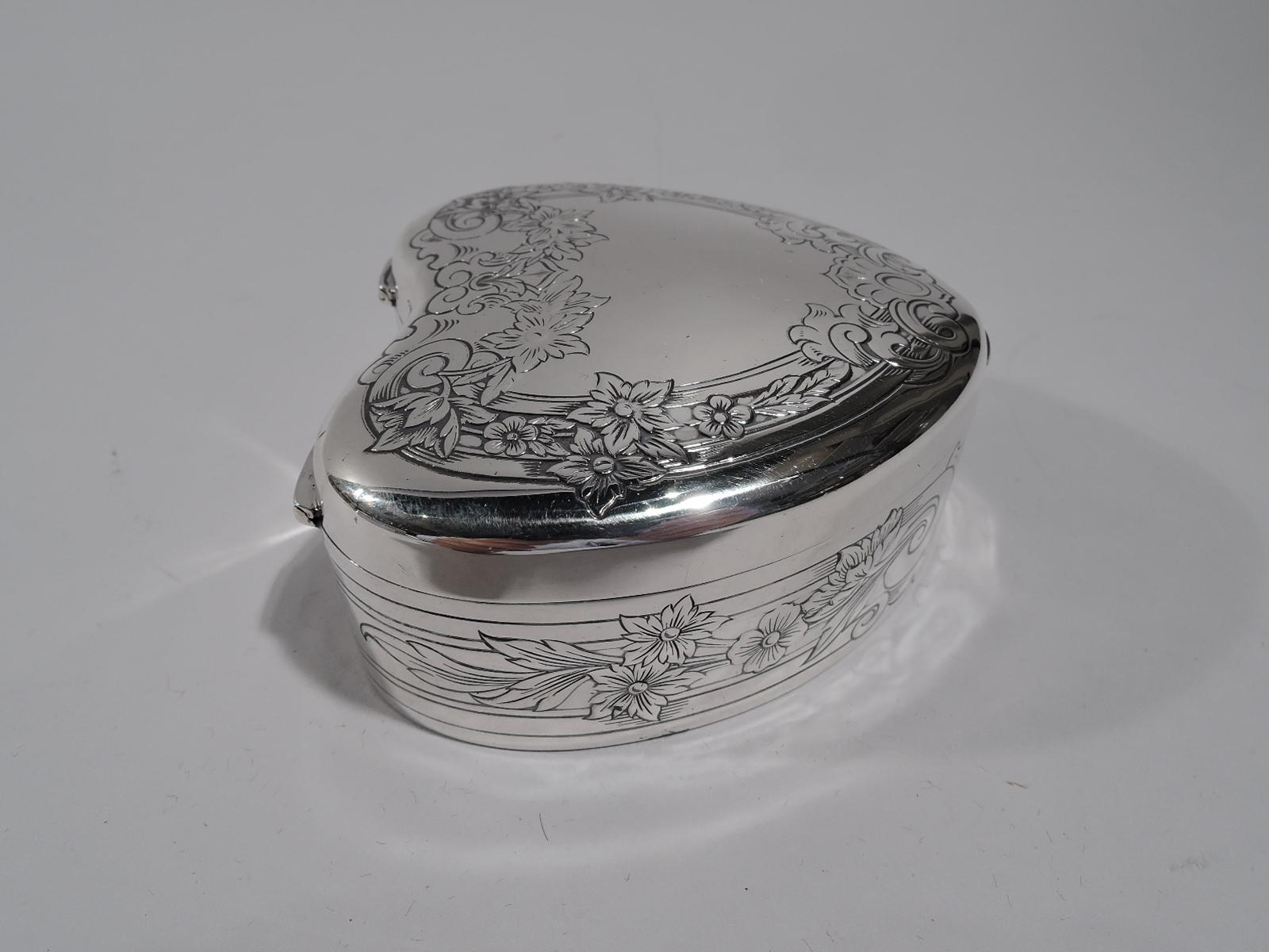 Romantic sterling silver jewelry box. Made by Gorham in Providence in 1912. Heart-form with hinged and curved cover. Engraved ornament. On sides: Wraparound pilasters with flowers and volute terminals. On cover: flower-entiwned scrolls forming