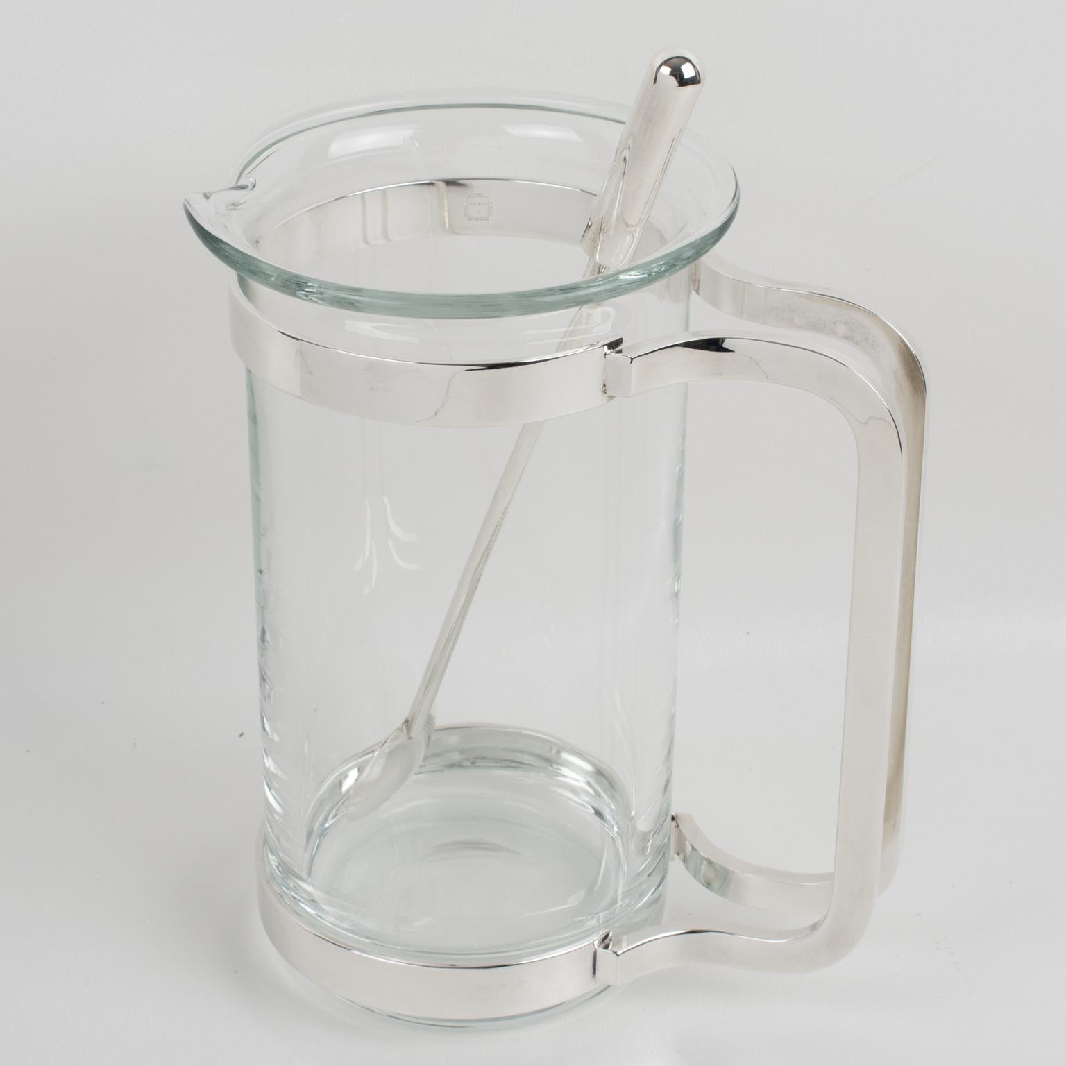 Gorham designed this streamlined barware set for its Maestri Collection circa 1997. The sleek and modernist design features a tall glass and silver plate Martini pitcher or mixer jug and a long stirrer spoon. The glass carafe with a lip for pouring