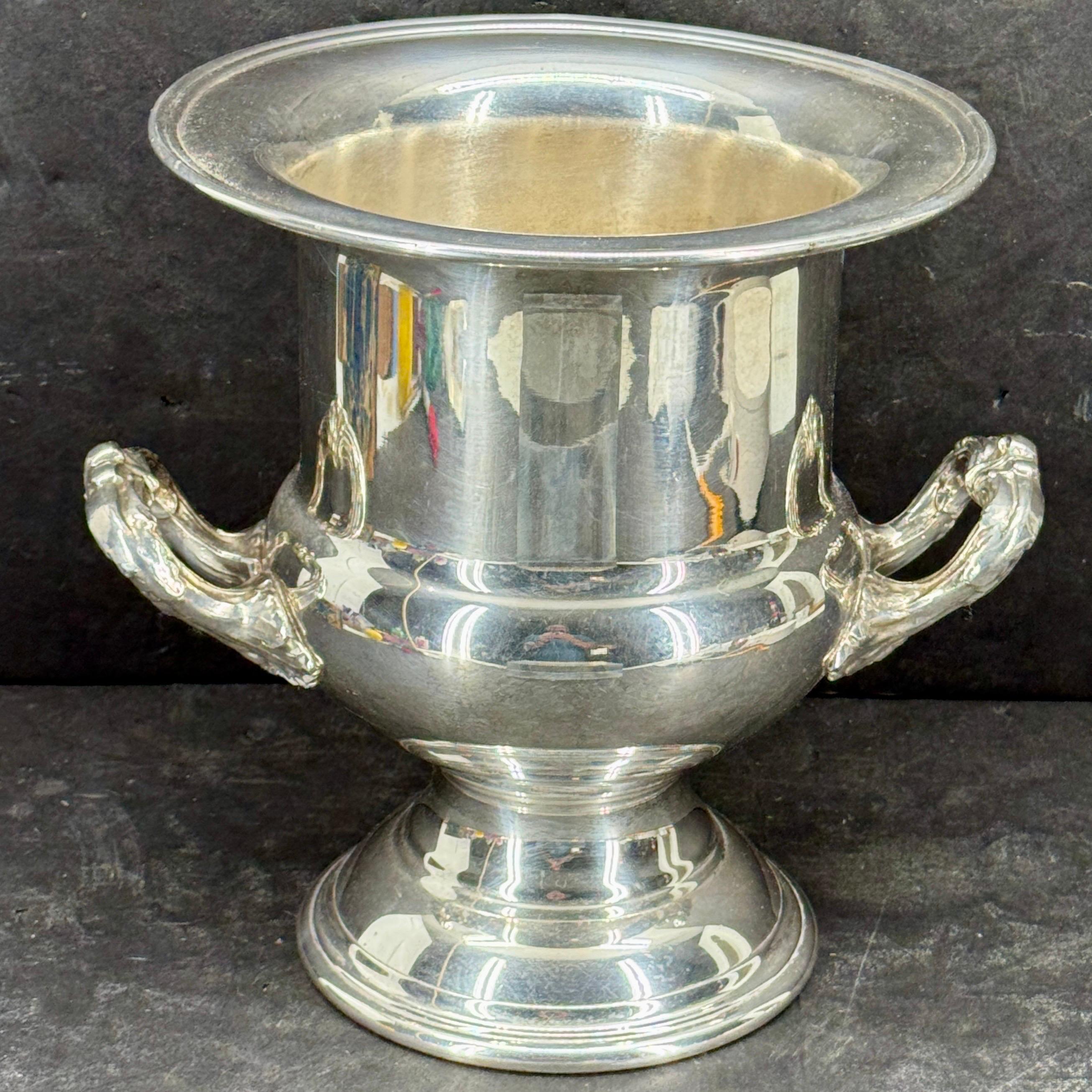 This impressive wine or champagne bucket features a silver plated finish. As seen throughout Europe, this wine holder will certainly elevate any occasion. We also could see this holding a bouquet of flowers as a centerpiece on a dining table. The