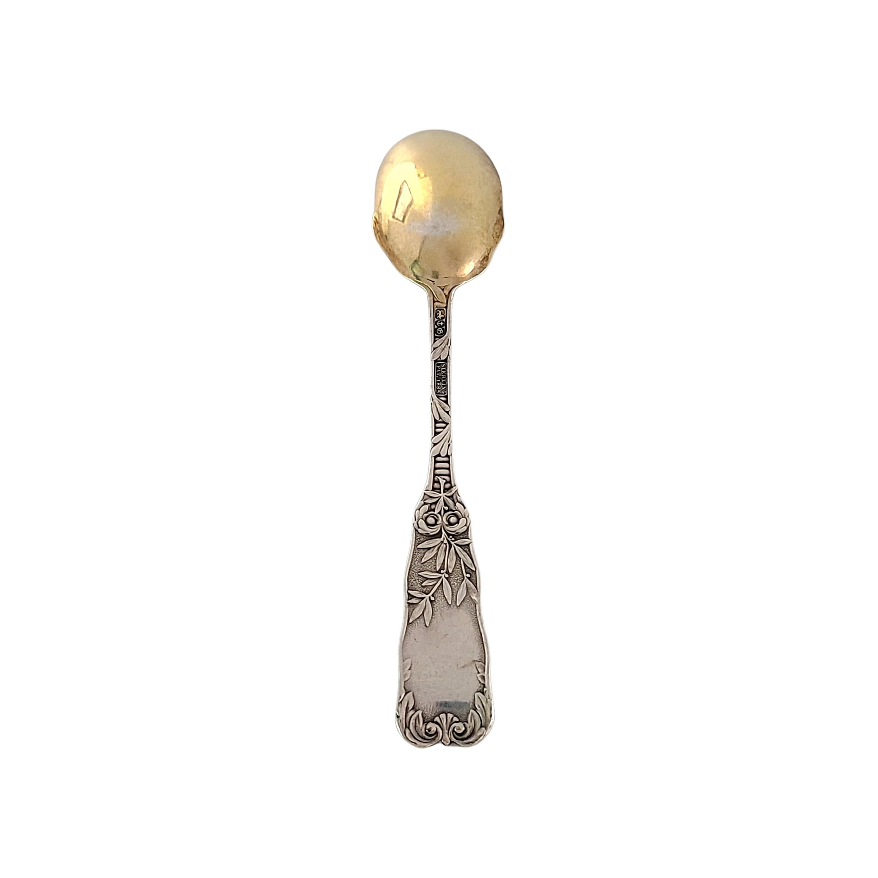 Sterling silver bright cut gold wash ice cream spoon by Gorham in the St Cloud pattern.

No monogram.

Gorham's St Cloud pattern was designed by Walter Wilkinson in 1885. This spoon features a scroll and leaf design on the handle and a gold wash