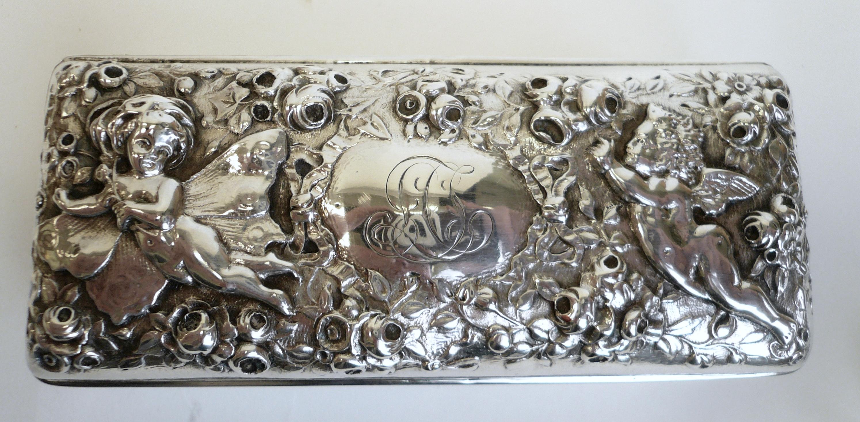 This sterling reposse box by Gorham features figures in a floral landscape.