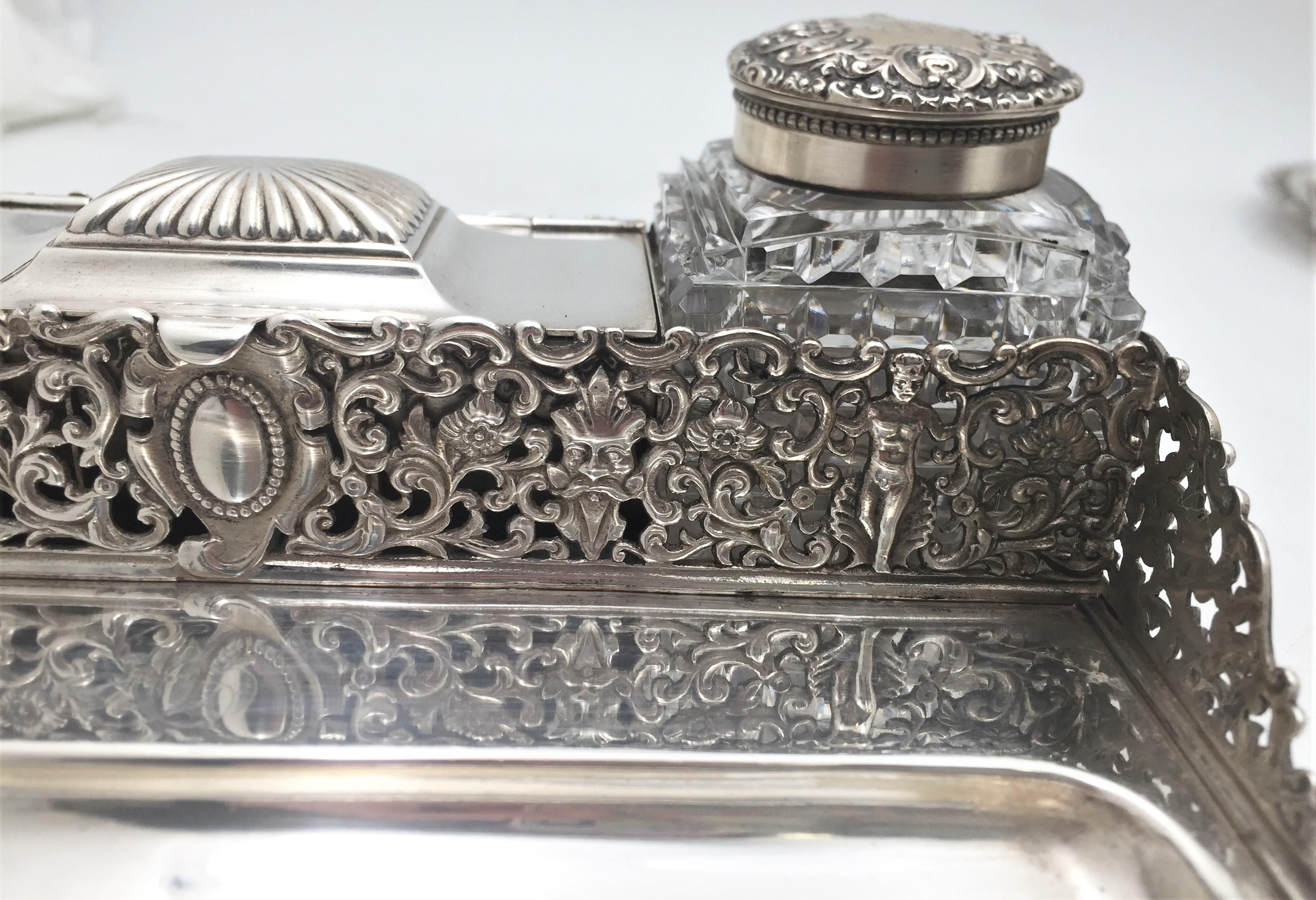 Gorham sterling silver tabletop double inkwell from 1886 with intricately pierced figural gallery. It contains two glass inkwells with sterling silver caps and has an open compartment with hinged door. A great gift and addition to one's home or