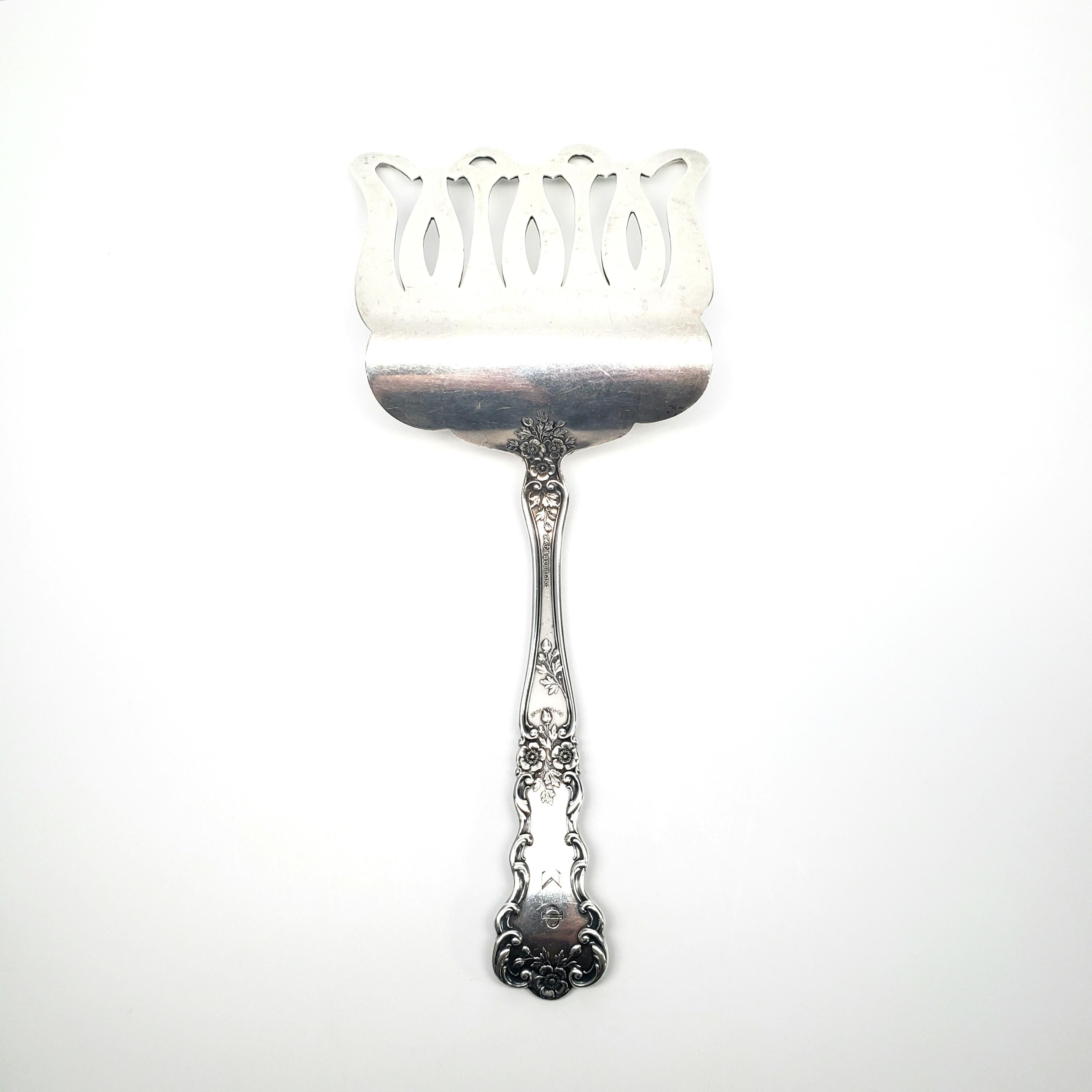 Antique sterling silver asparagus server by Gorham in the Buttercup Pattern

Gorham's Buttercup pattern was introduced in 1900. This rare piece has a solid handle with a curved 4 prong server. The monogram on the front of the handle appears to be