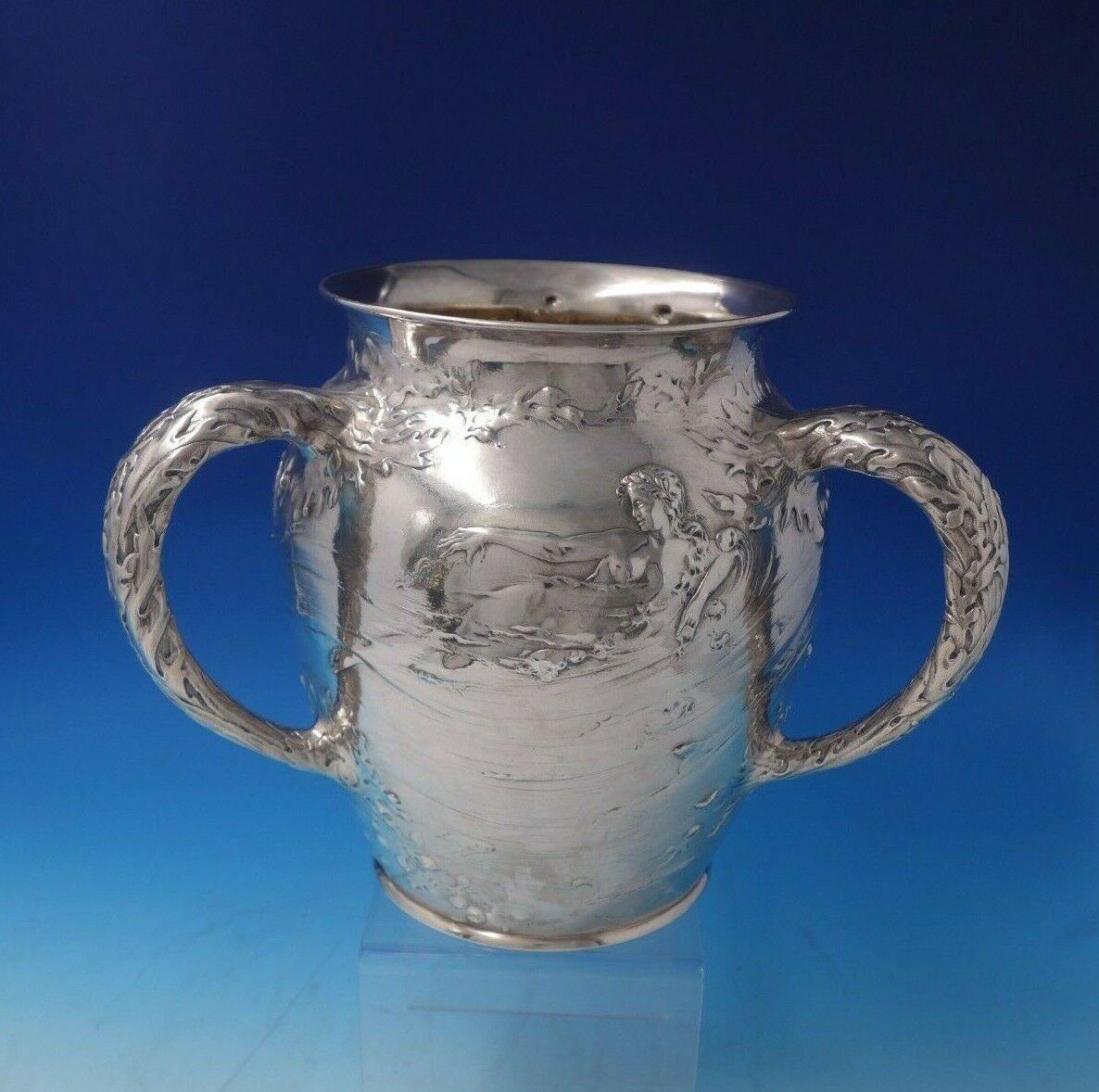 Gorham

Beautiful Gorham sterling silver champagne cooler marked #7773 with gold washed interior. This piece features three handles and seaweed, fish, waves, and nude swimming goddess motif (two scenes). It holds 9 pints, measures 9