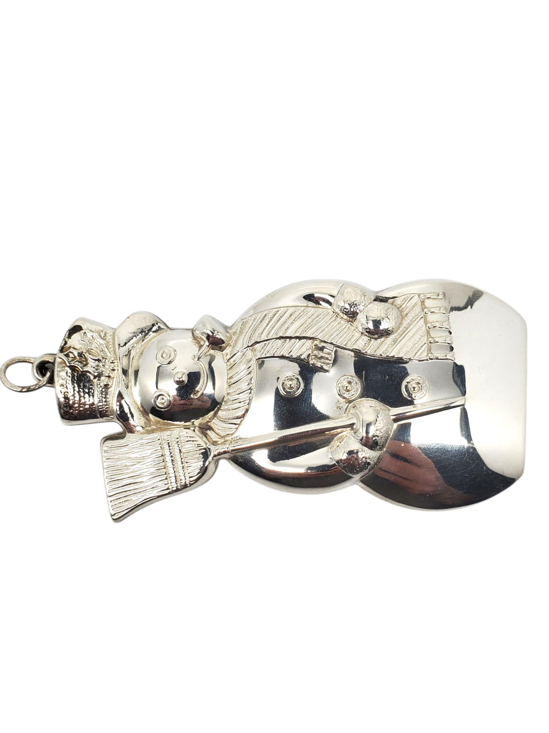 Gorham Sterling Silver Christmas Snowman Ornament 1350 

This vintage Gorham sterling silver Christmas Ornament features a jolly snowman with a broom, scarf & top hat.
Could also be worn as a pendant.

Size: 93 mm x 44 mm x 6 mm / approx. 3.5