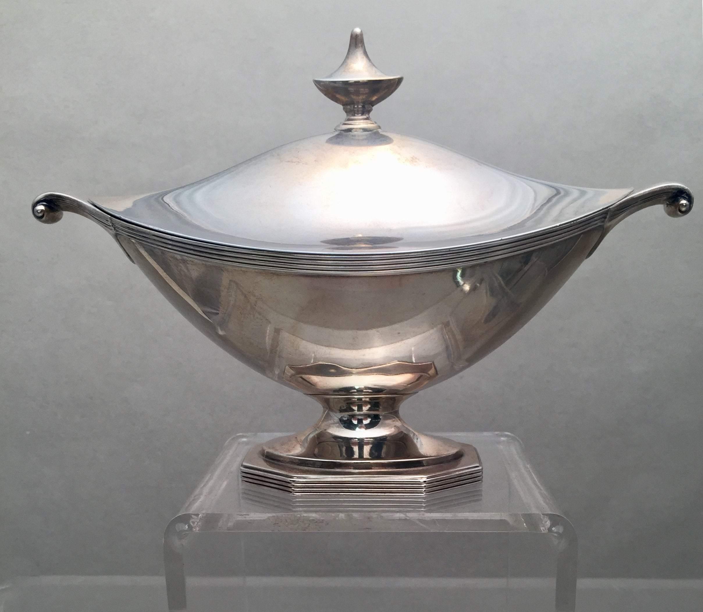 Sterling silver gravy tureen by the famous American maker Gorham in the Georgian style, shaped like Aladdin's lamp. Designed with a repetitive line pattern going around rim and base curled handles on both sides as well as a pointed finial atop.