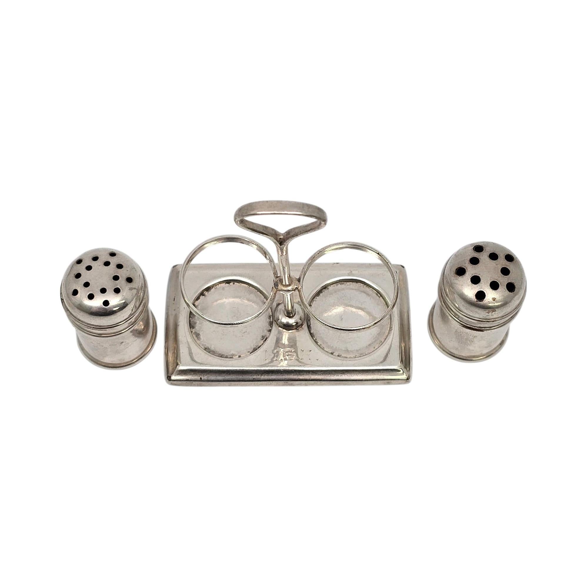 Gorham sterling silver salt and pepper shakers and caddy with monogram.

Monogram appears to be MGH (monogram is very worn, see photos).

Small cylindrical round dome topped salt and pepper shakers on a small caddy.

Shakers measure approx 1 1/4