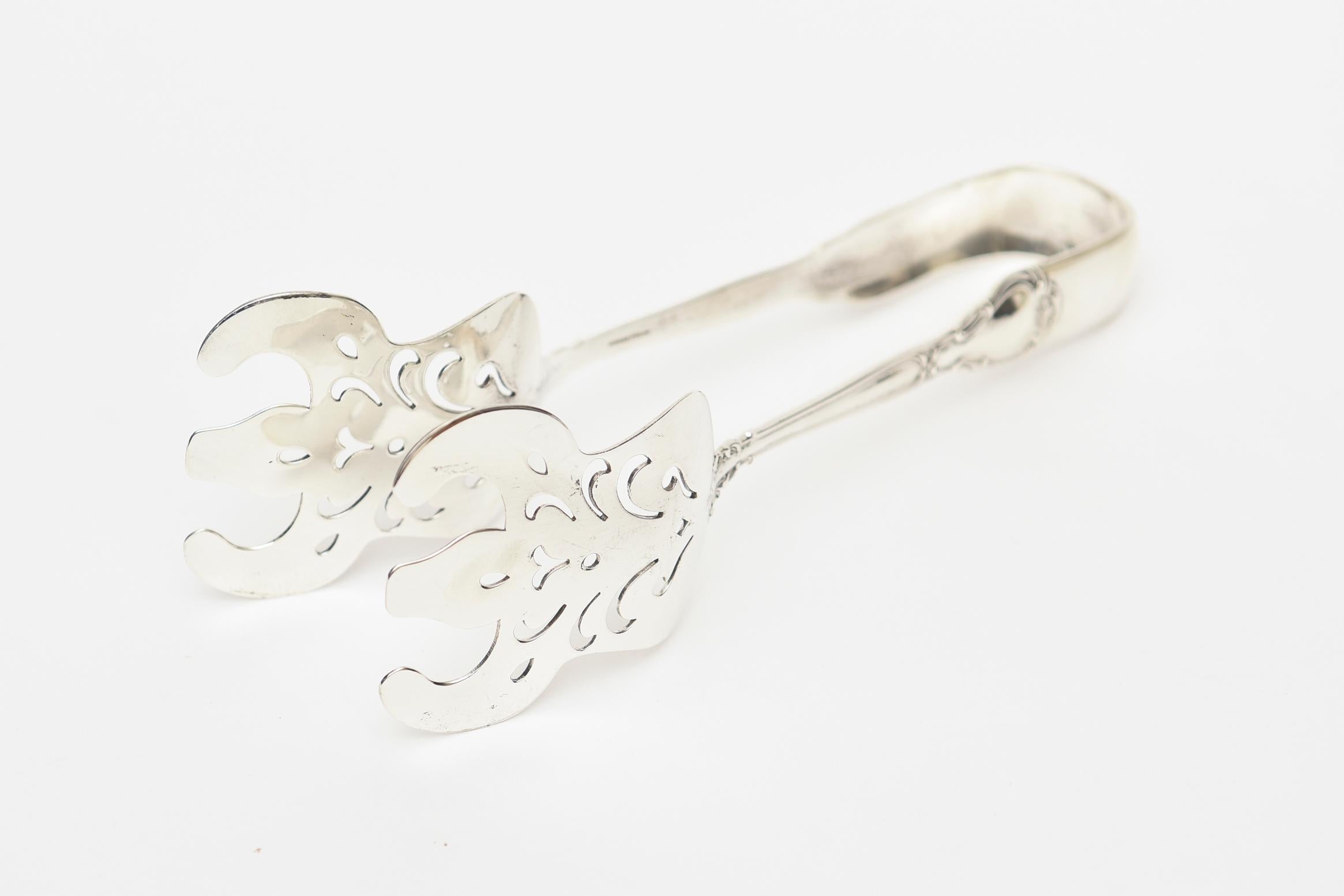 This lovely Gotham vintage sterling silver thongs are great for serving vegetables, asparagus and makes a beautiful addition to any elegant table setting. The design is more fleur-de-lis.
  