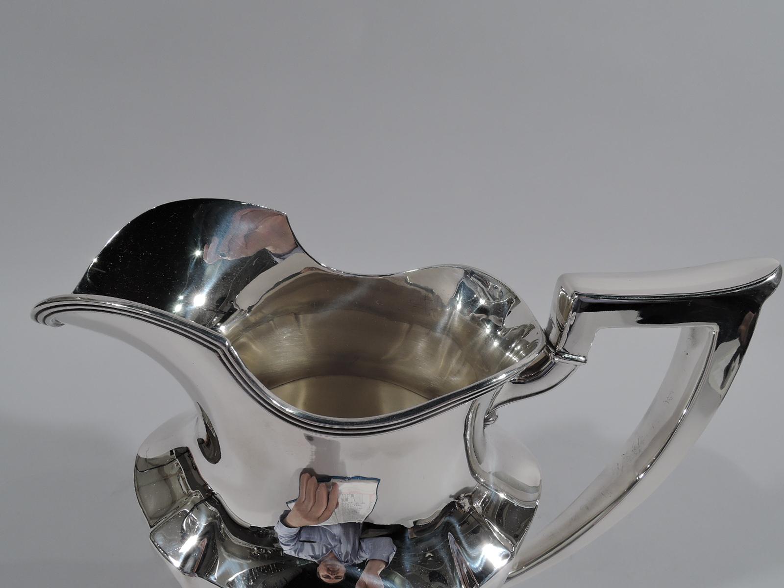Plymouth sterling silver water pitcher. Made by Gorham in Providence in 1931. Tapering and paneled ovoid body, reeded helmet mouth, capped scroll bracket handle, and stepped oval foot. A fine piece in the Classic Art Deco pattern. Fully marked