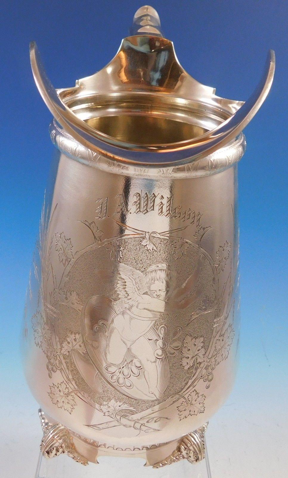 Gorham
Gorham sterling silver water pitcher featuring a large detailed engraving of a winged angel and grapes. This piece measures 11 x 9, weighs 34.3 troy ounces, and is monogrammed (see photos). It is marked #785 and date mark for 1871. It is in