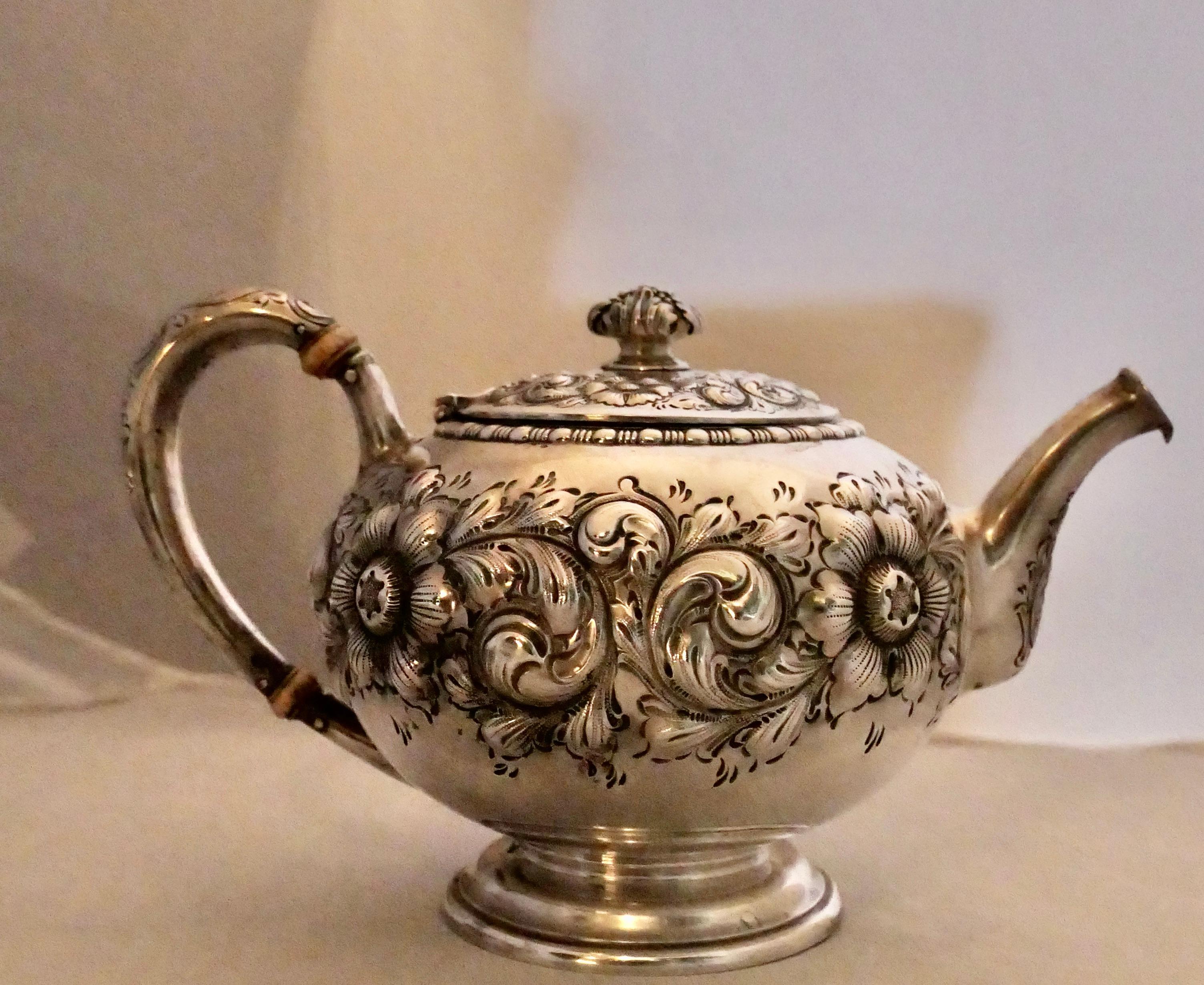 Dieses dekorative viktorianische Teeservice aus Sterlingsilber ist wunderschön gestaltet und stammt aus dem späten 19. Jahrhundert. Das dreiteilige Teeservice zeichnet sich durch ein aufwändiges repoussiertes Blumenmotiv aus, das den Korpus jedes