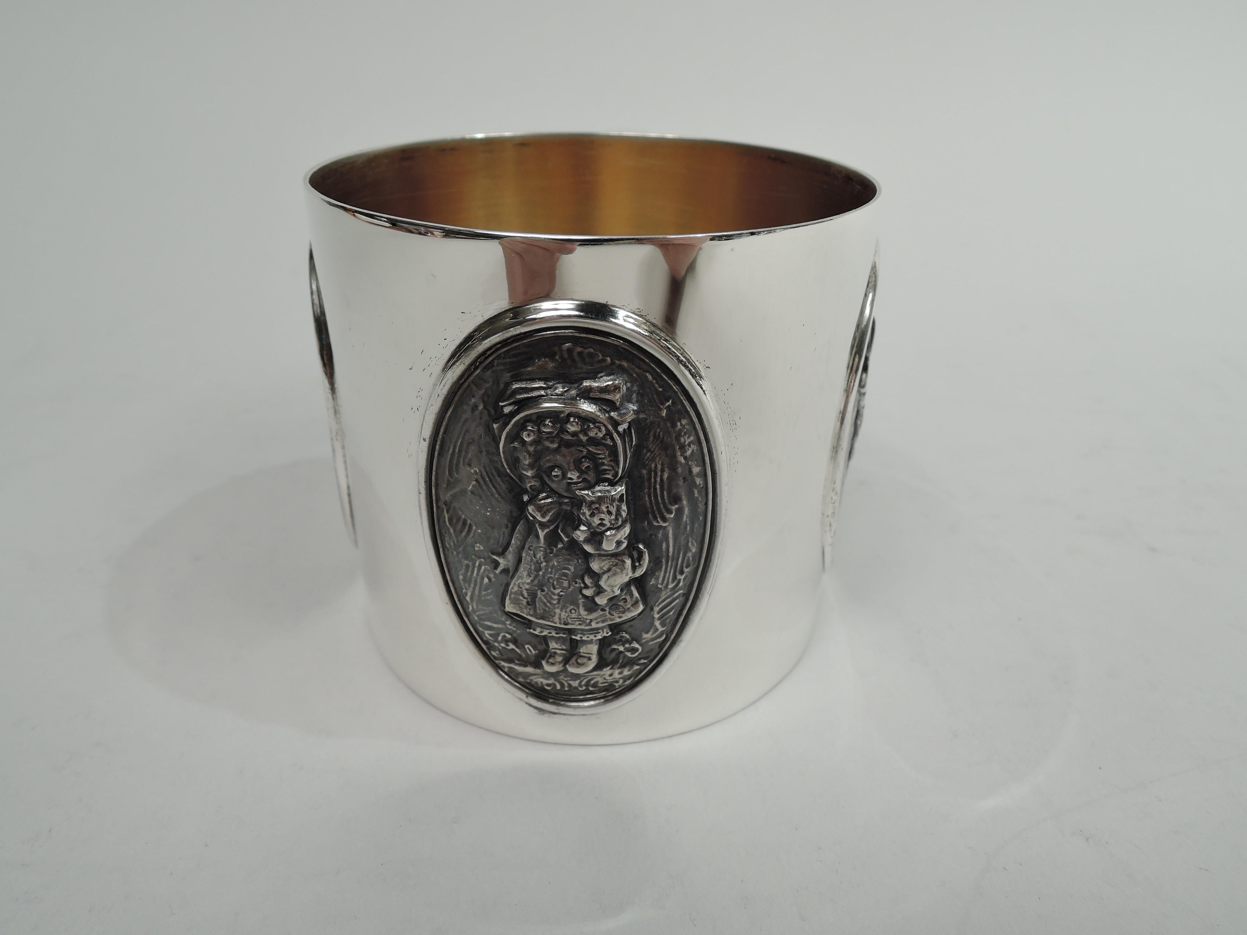 Victorian sterling silver baby cup. Made by Gorham in Providence, circa 1890. Straight and gently upward tapering sides and scroll-bracket handle. Applied cast oval medallions that depict not austere Roman patricians and their virtuous helpmates but