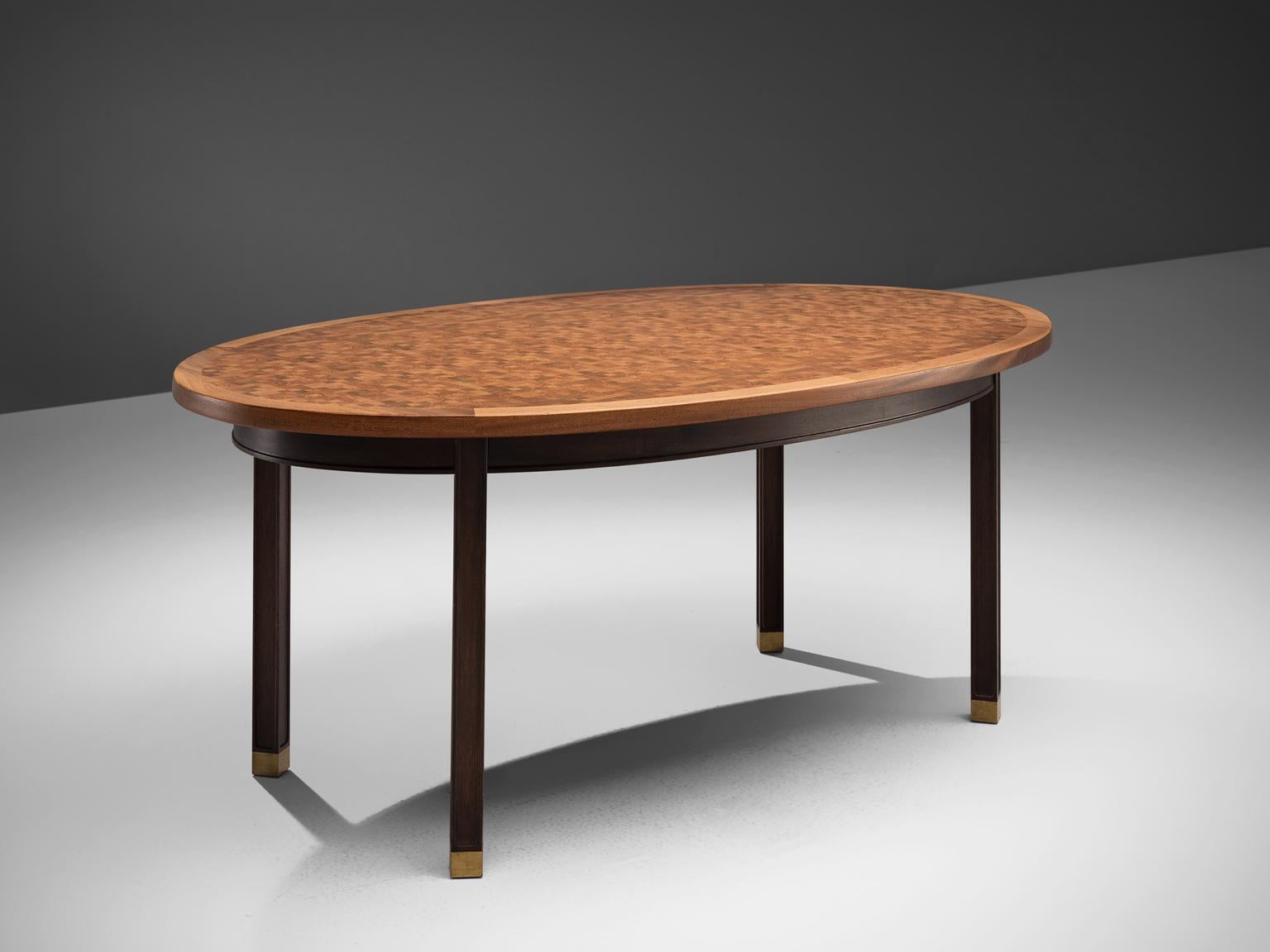 Gorm Lindum, checked oval dining table, mahogany and brass, Denmark, 1970s. 

This inlaid centre table by the Danish architect Gorm Lindum has a mosaic structured tabletop, that consist of cubical pieces end-grain mahogany wood. These pieces vary