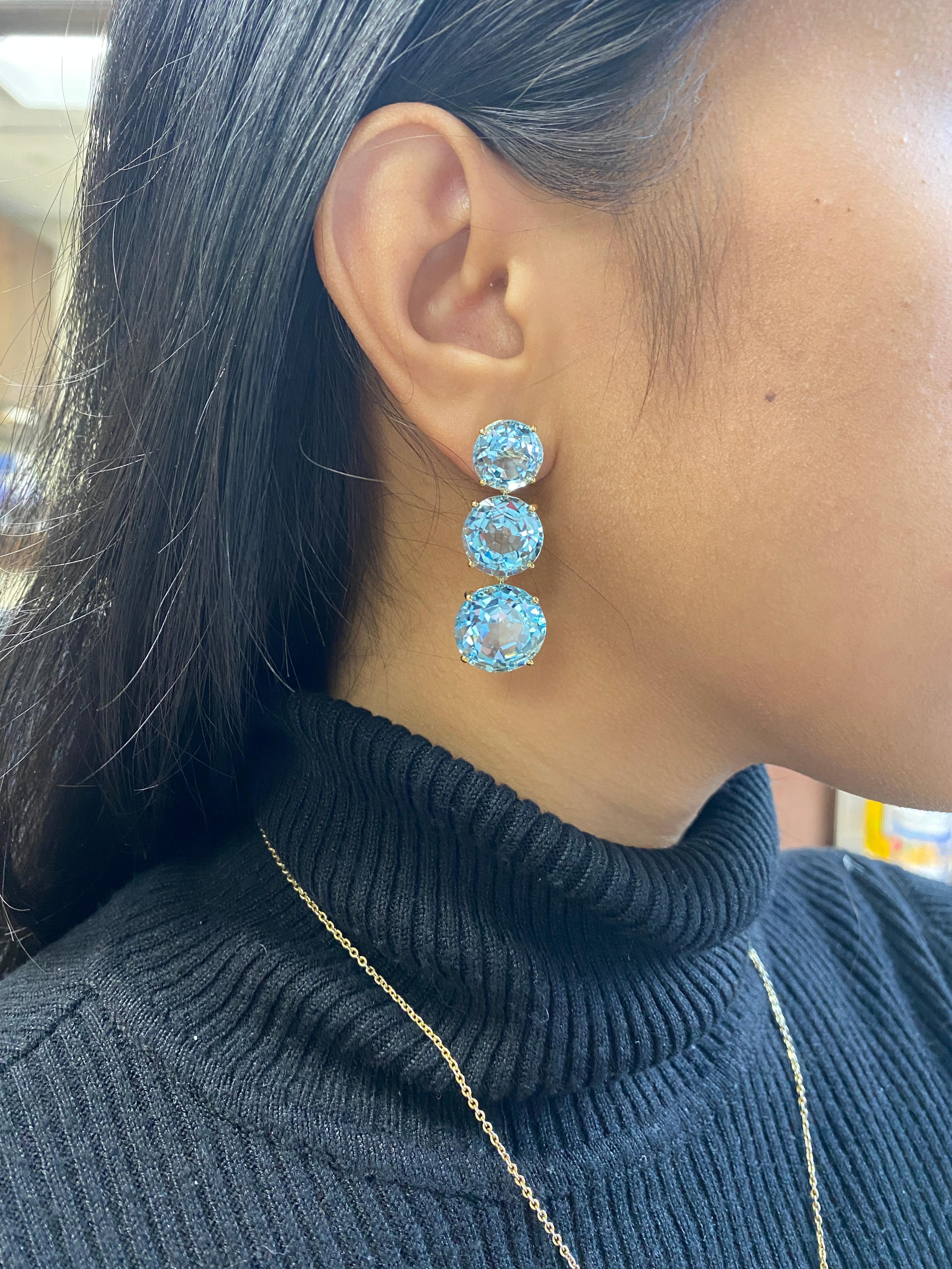 3 Tier Round Faceted Blue Topaz Earrings in 18k Yellow Gold, from ‘Gossip' Collection.  Like any good piece of gossip, this piece carries a hint of shock value.

* Gemstone size: 15, 13 & 11 mm
* Gemstone: 100% Earth Mined 
* Approx. gemstone