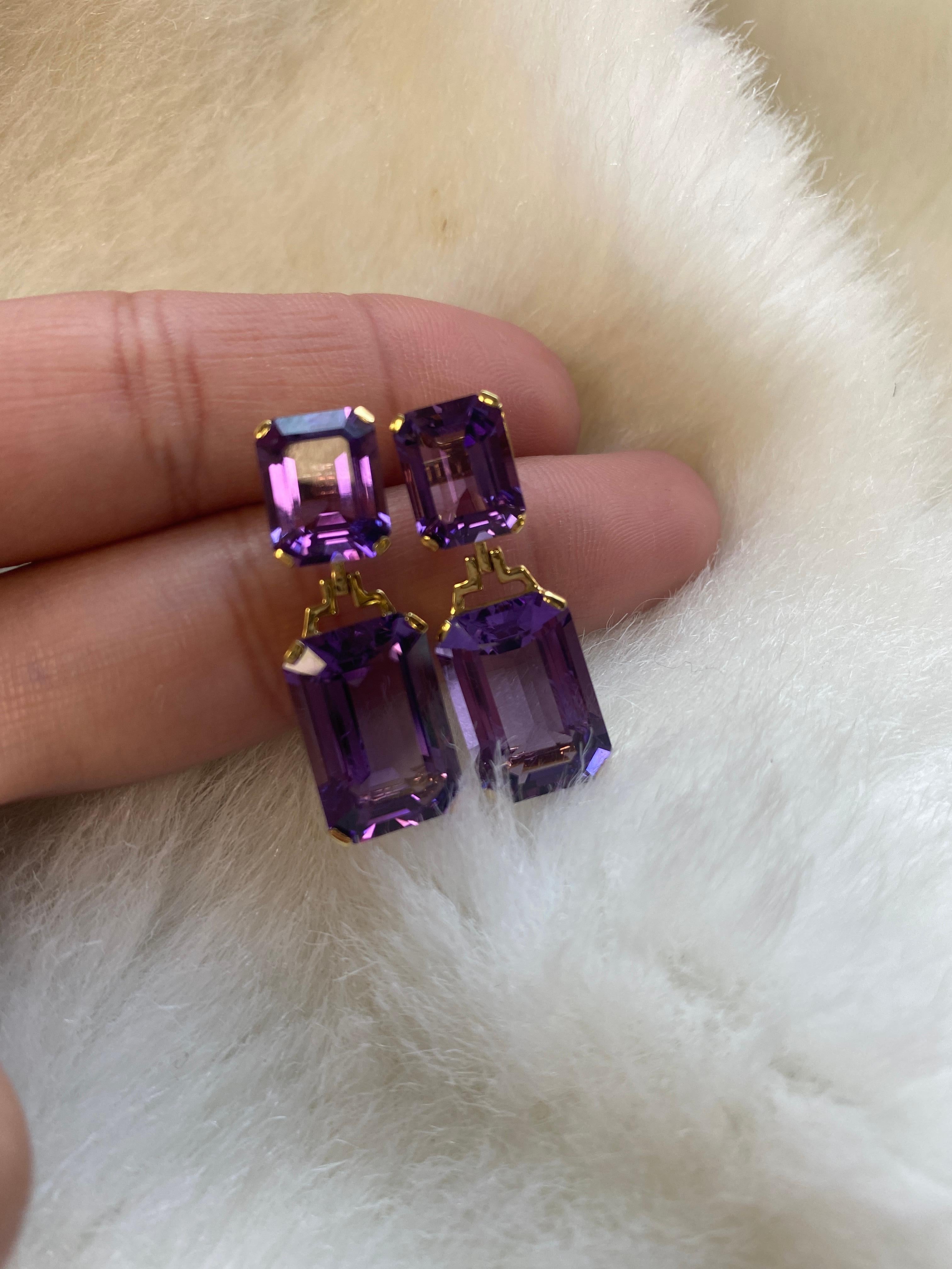 These Amethyst Double Emerald Cut Earrings in 18K Yellow Gold from the 'Gossip' Collection are a show-stopping accessory. The deep purple hue of the amethyst stones combined with the double emerald cut design creates a striking and unexpected look.