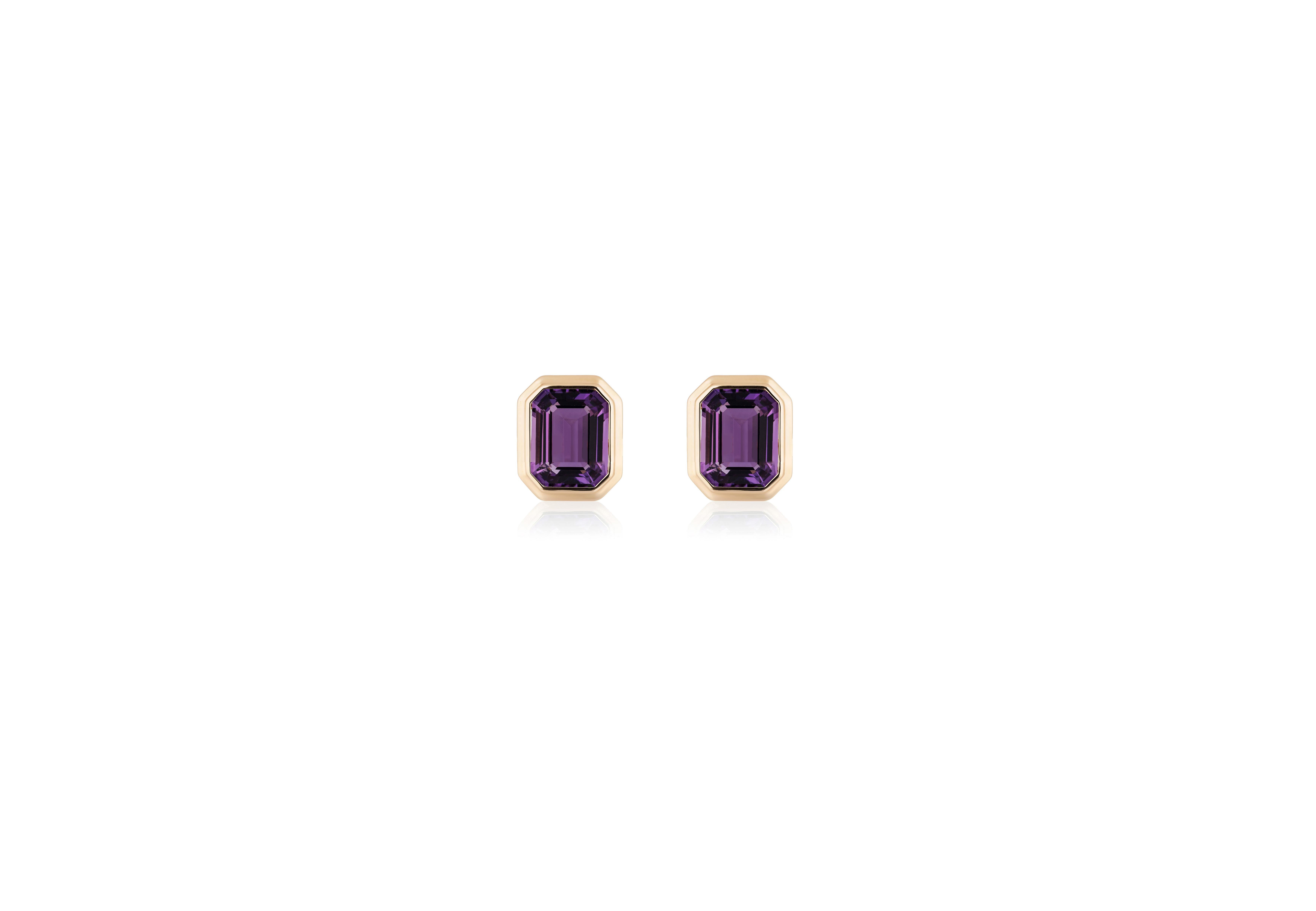 These Amethyst Emerald Cut Bezel Set Stud Earrings in 18K Yellow Gold, part of the exquisite 'Manhattan' Collection, are a stunning embodiment of timeless elegance. These earrings feature rich amethyst gemstones with a striking emerald-cut design,