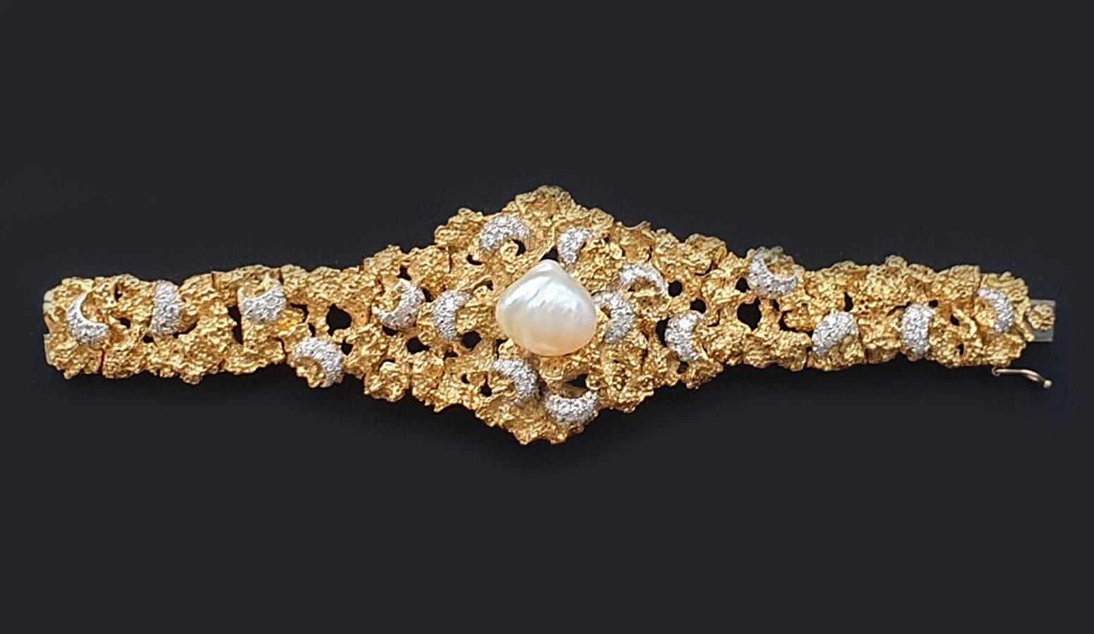 Dieses barocke Perlen- und Diamantarmband ist ein elegantes Schmuckstück, in dessen Mittelpunkt eine wunderschöne, unregelmäßig geformte Perle steht. Die Perle ist von funkelnden Diamanten umgeben, die in 18 Karat Gelbgold gefasst sind und dem