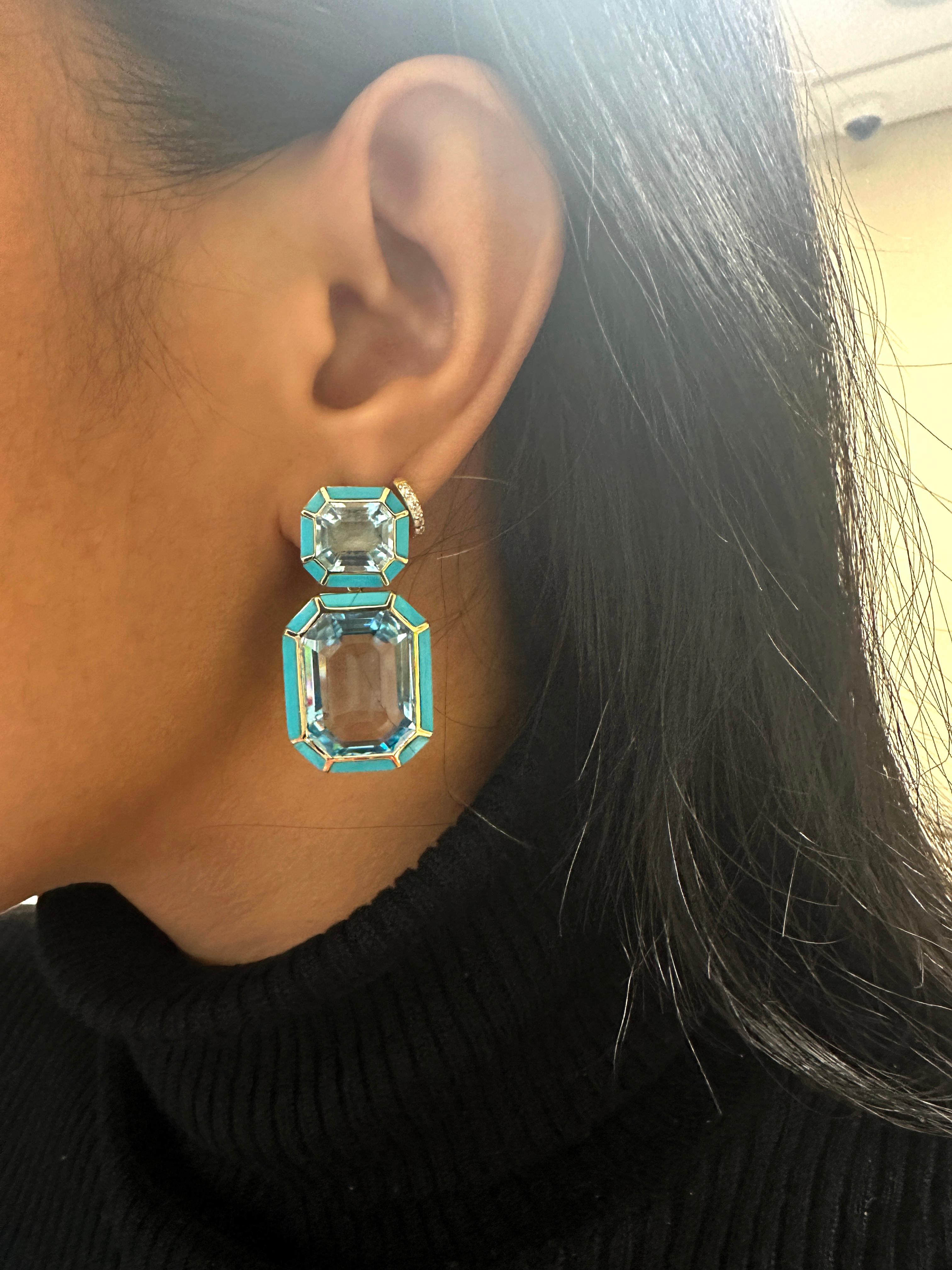 These Blue Topaz and Turquoise Emerald Cut Earrings in 18K Yellow Gold are a stunning addition to the 'Mélange' Collection. The earrings feature a beautiful blend of blue topaz and turquoise gemstones, cut in an emerald shape, and set in 18K yellow