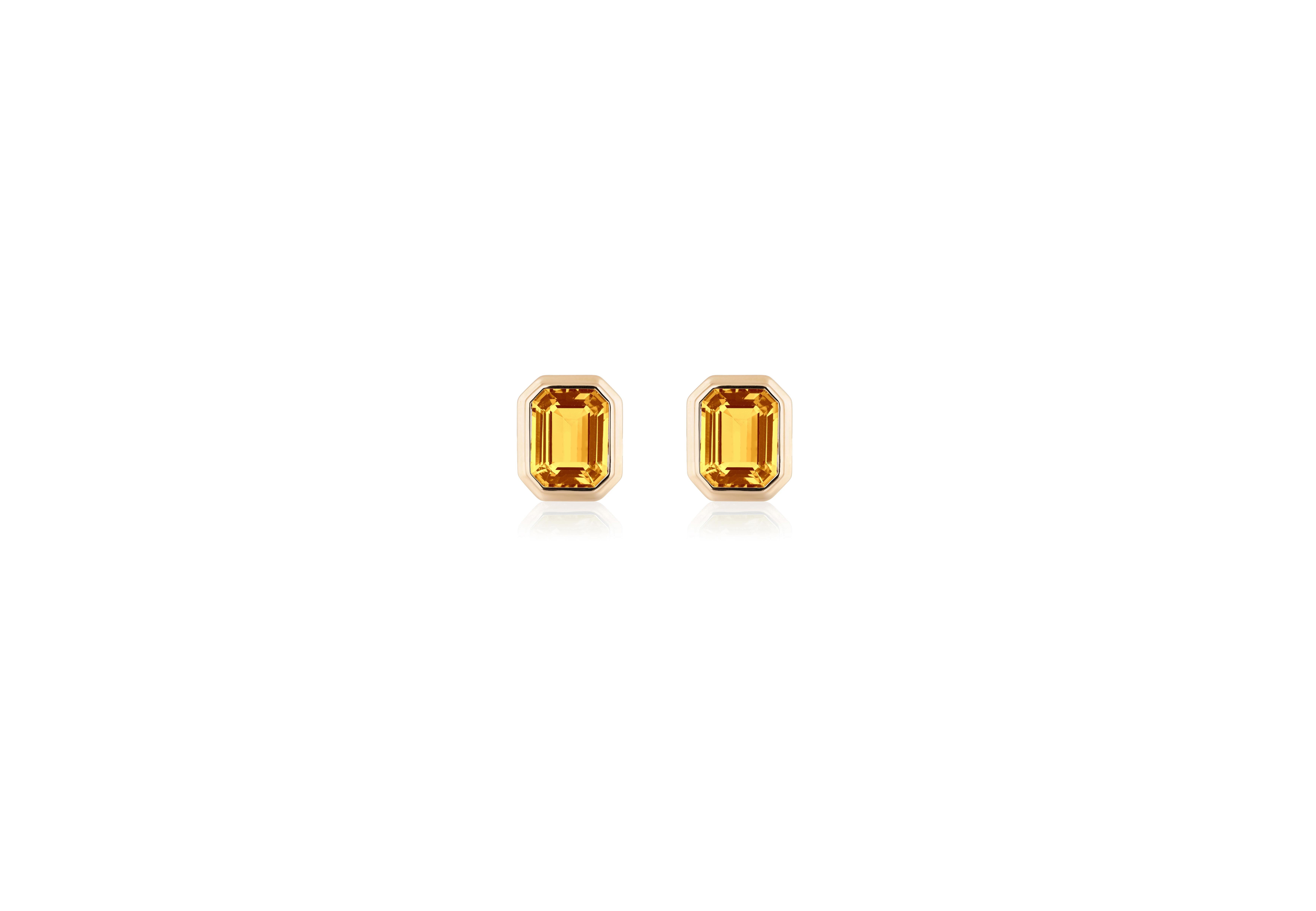 The Cirine Emerald Cut Bezel Set Stud Earrings in 18K Yellow Gold are exquisite jewelry pieces from the 'Manhattan' Collection. These elegant earrings feature a timeless emerald-cut gemstone securely held in a bezel setting, exuding a sense of