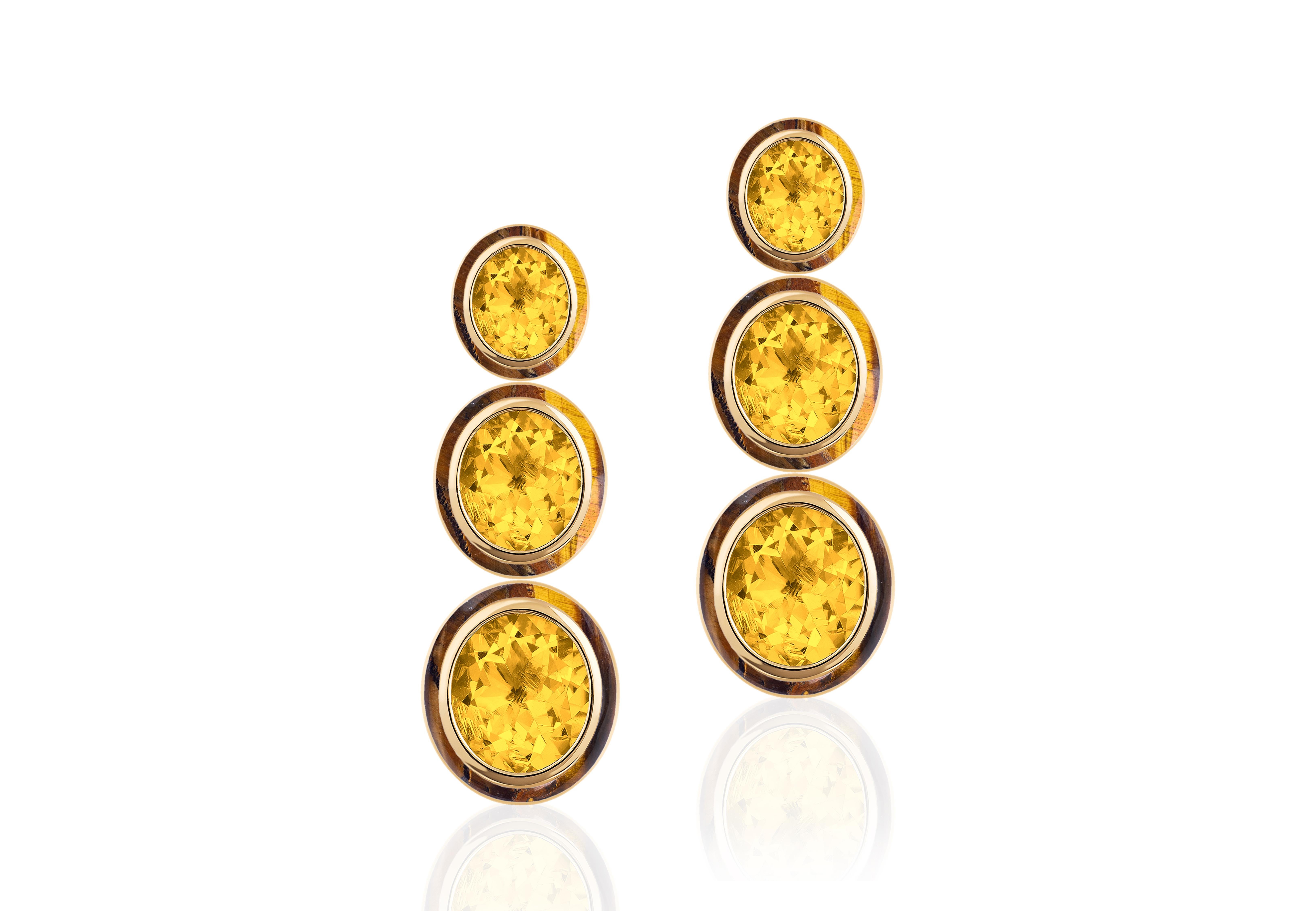 The Melange earrings are a stunning piece of jewelry featuring a three-tiered oval shape design. Made of 18K yellow gold, they feature Citrine and Tiger's Eye gemstones, creating a beautiful melange of warm, golden hues. These earrings are perfect