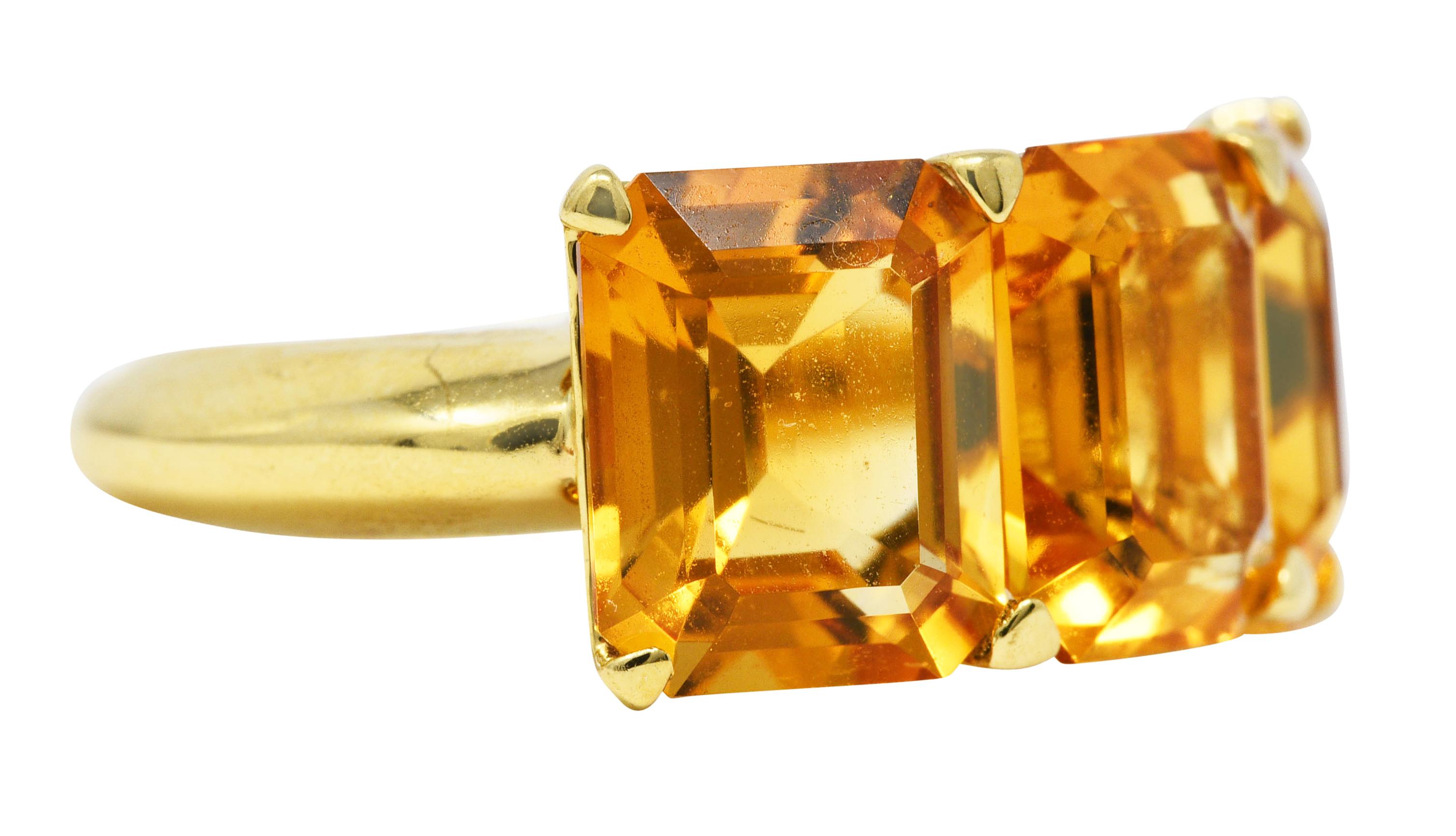 Ring features three basket set and emerald cut citrines. Eye clean and very well matched in yellowish orange color - medium saturation. Each measuring approximately 10.0 x 8.0 mm. Completed by a polished gold knife edge shank. Stamped 750 for 18