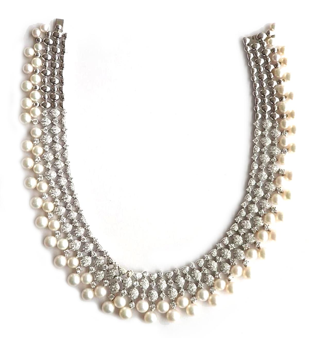 This Cultured Pearl & Diamond Necklace in 18K Gold is a luxurious and stunning piece of jewelry that features a unique and intricate design of pearls and diamonds. The pearls are of high quality and are cultured, giving them a beautiful and