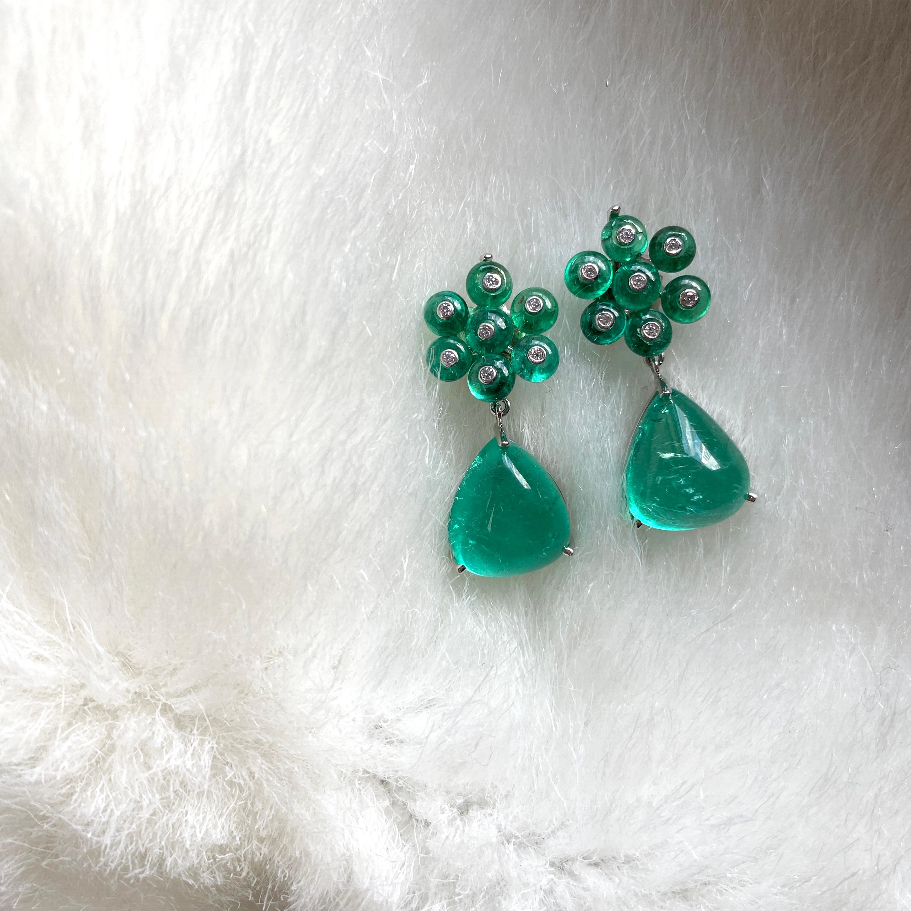 These Emerald Cab with Small Emerald Beads Flower Earrings in White Platinum are exquisite jewelry pieces from the 'G-One' Collection. These elegant earrings feature an emerald bead at their center, surrounded by delicate small emerald beads that