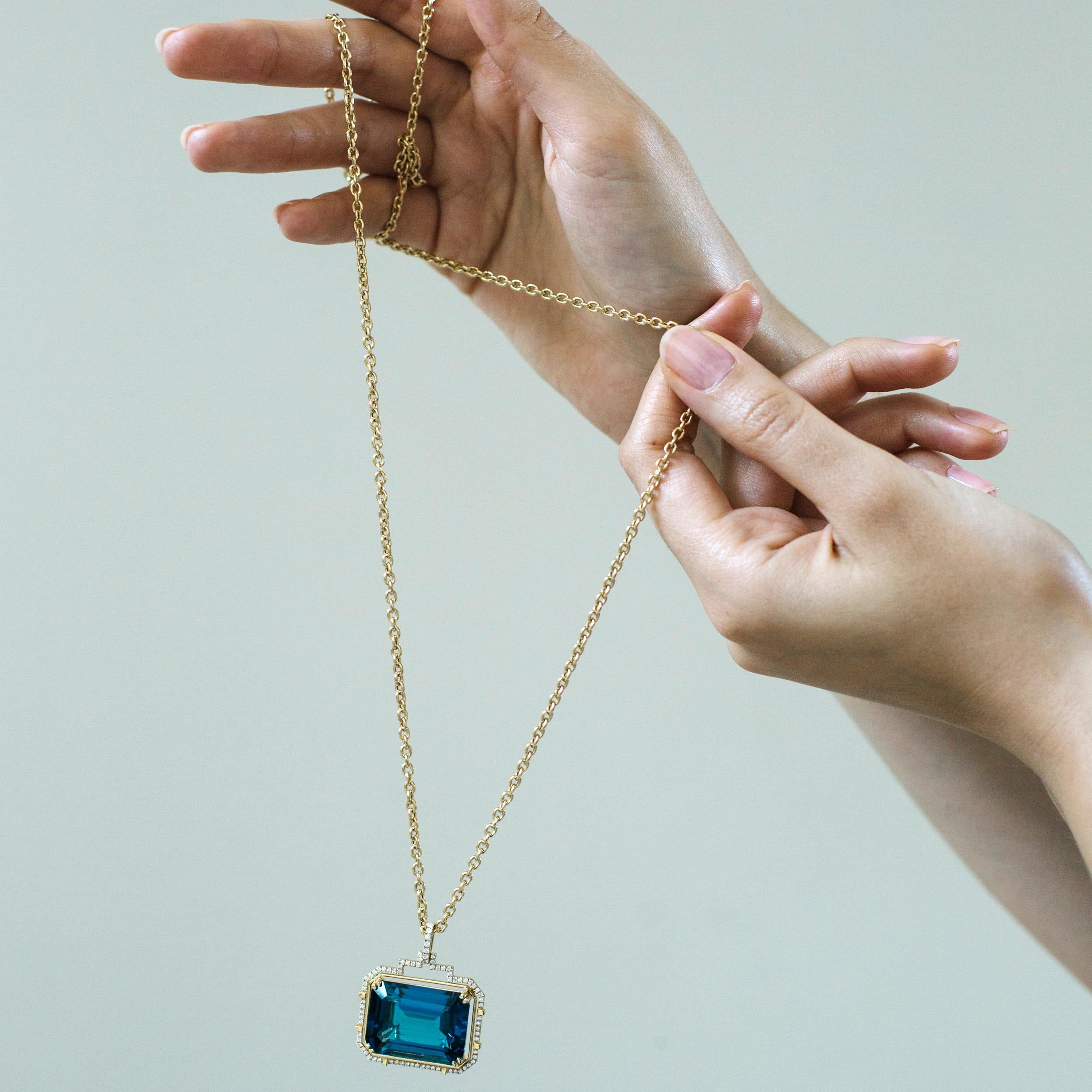 Introducing the epitome of elegance: the London Blue Topaz Emerald Cut Pendant from the exquisite 'Gossip' Collection. Crafted in lustrous 18K yellow gold, this pendant is a mesmerizing blend of sophistication and allure. The centerpiece features a