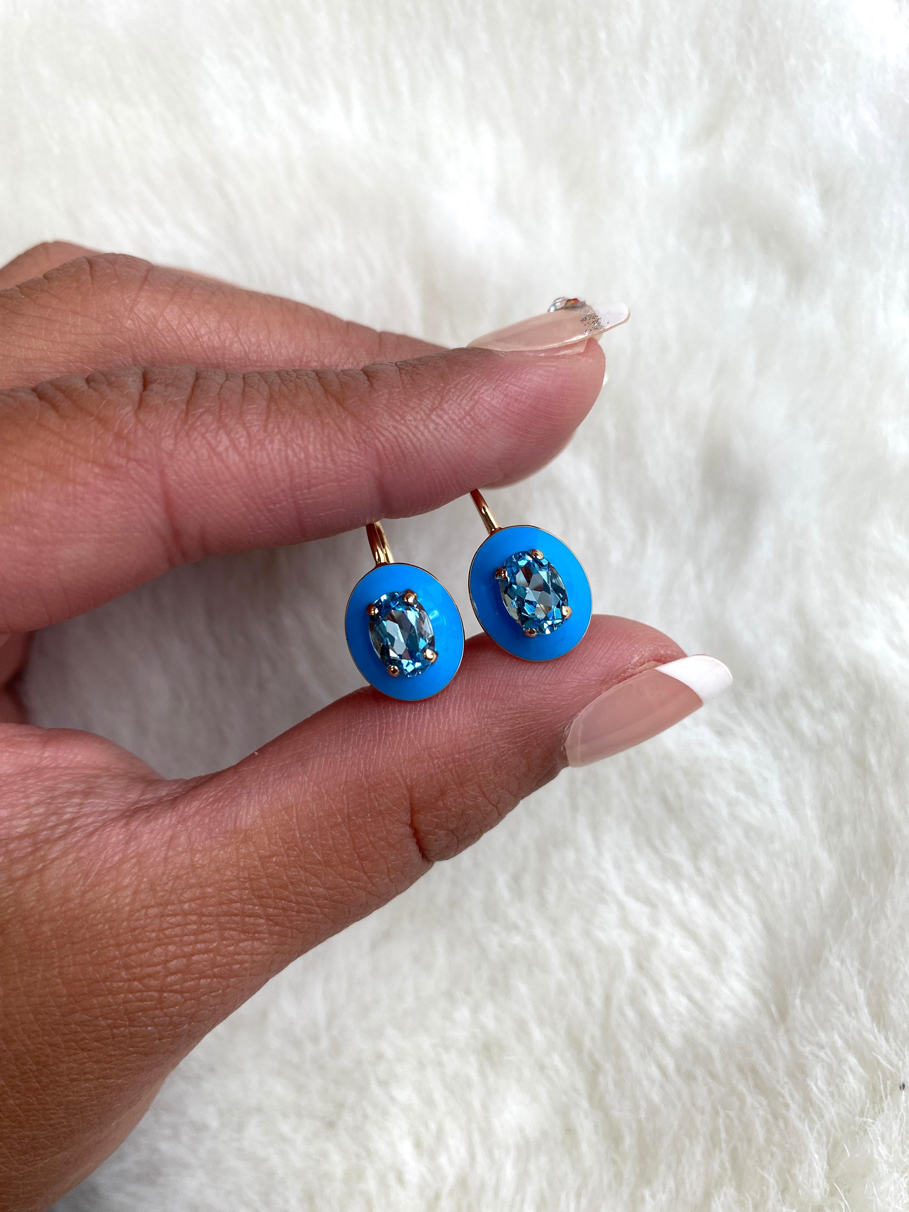 Diese einzigartigen Ohrringe sind ein facettierter ovaler Blautopas mit türkisfarbener Emaille-Bordüre und Hebelverschluss. Es stammt aus unserer Queen